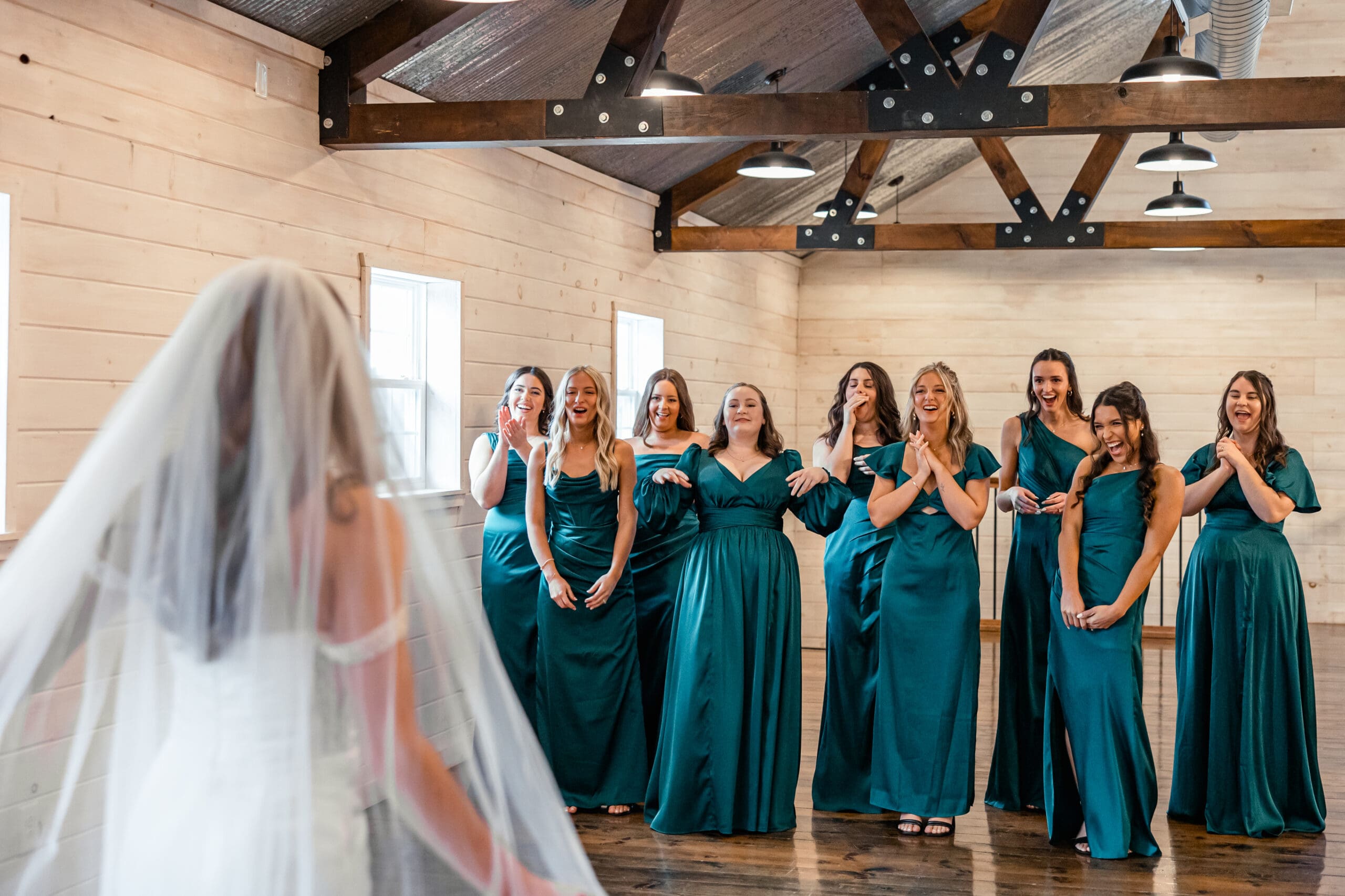 Bridesmaids reacting to bride during first look before winter wedding ceremony