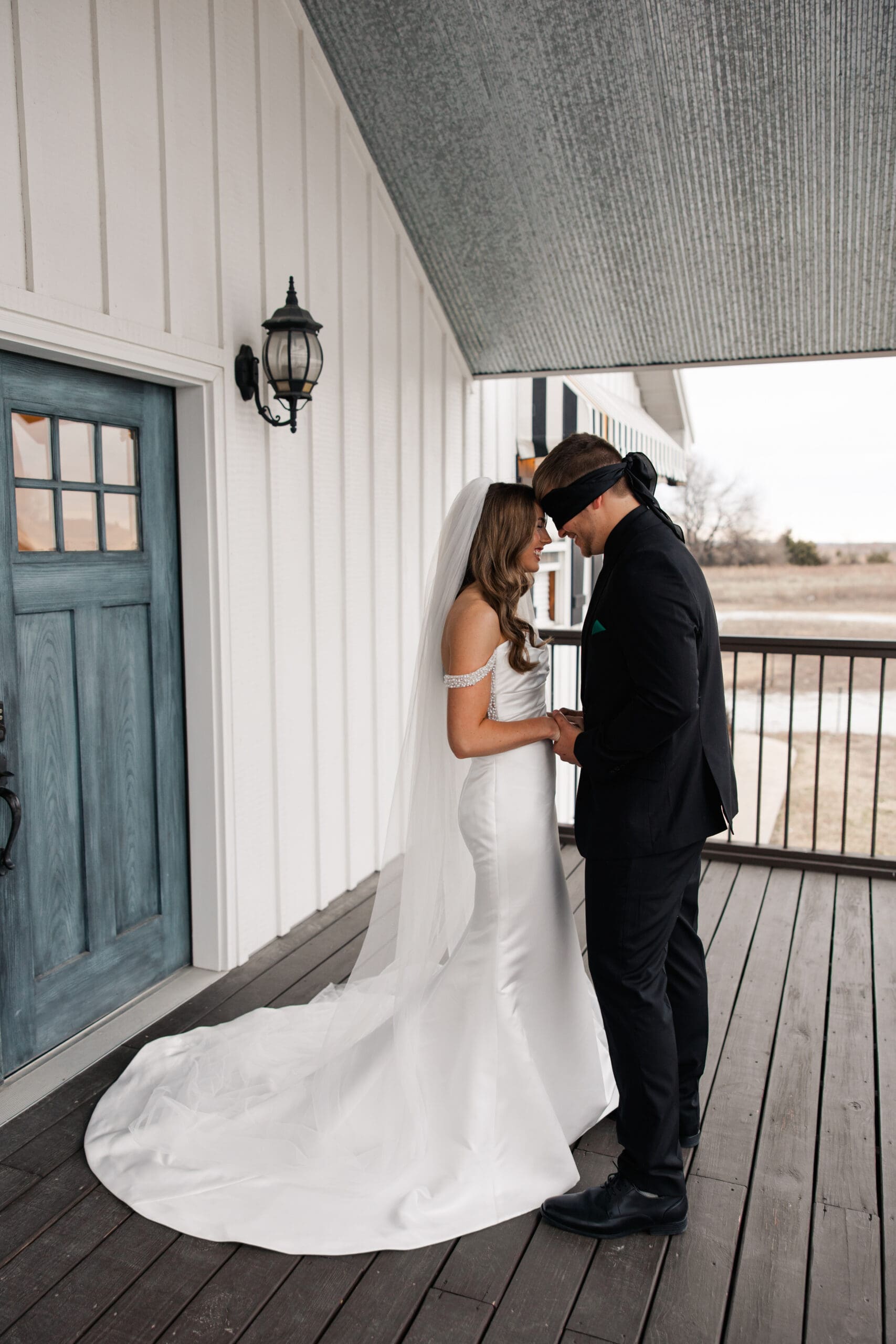 Bride and blindfolded groom praying together before ceremony at The Silver Spoon Barn