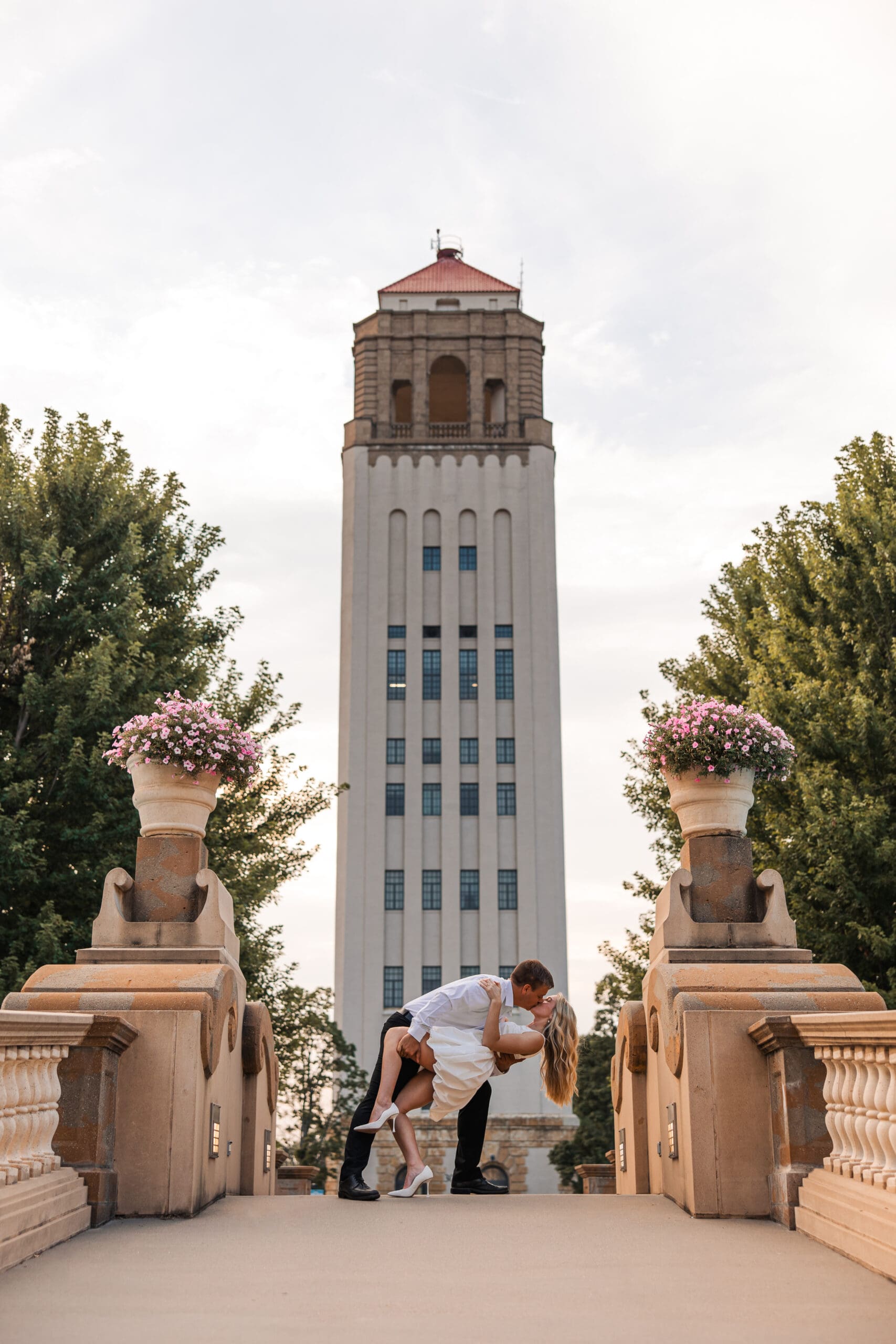 Engagement photo of couple at Unity Village surrounded by florals and architecture