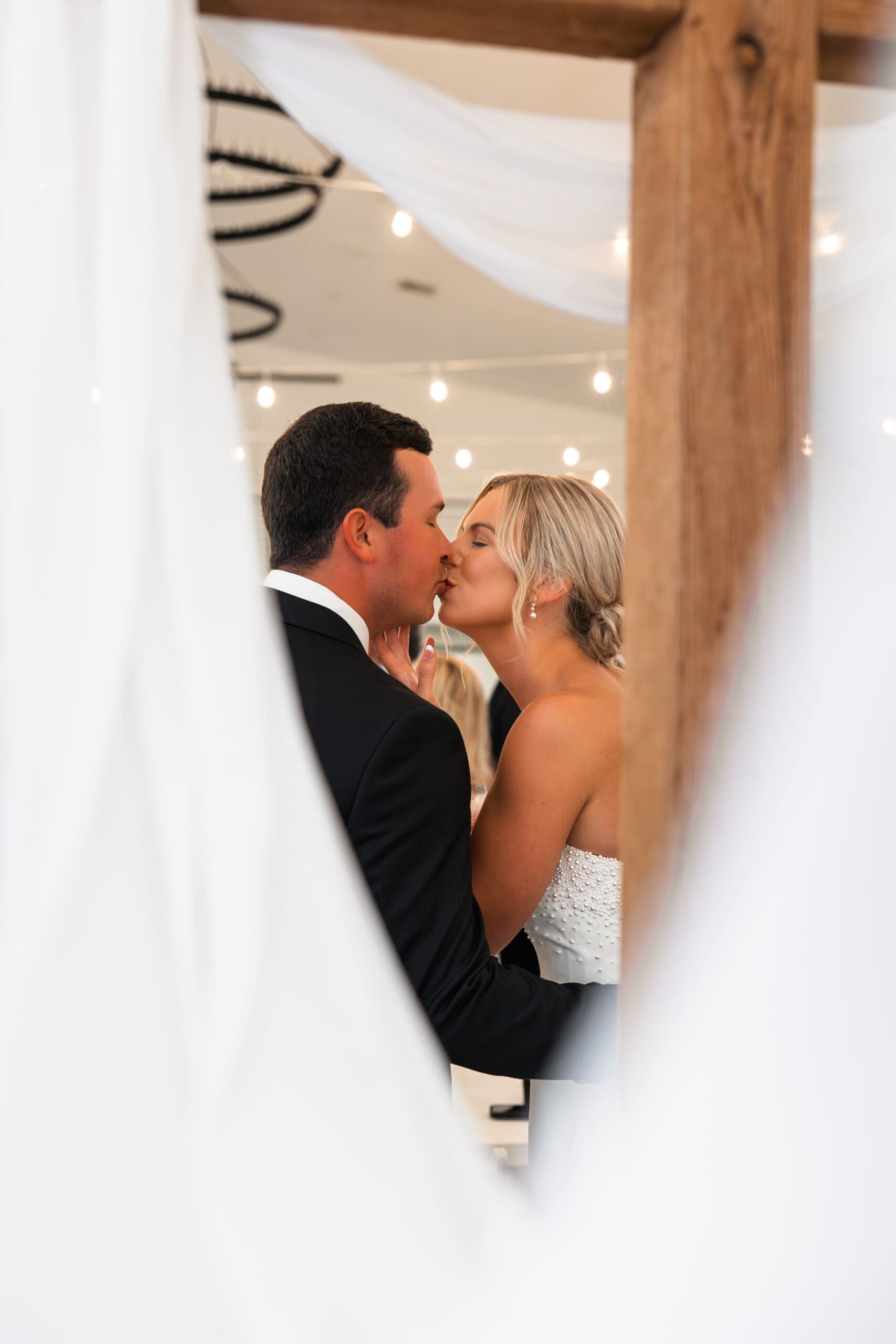 Bride and groom kiss Barn at Grace Hill wedding reception.