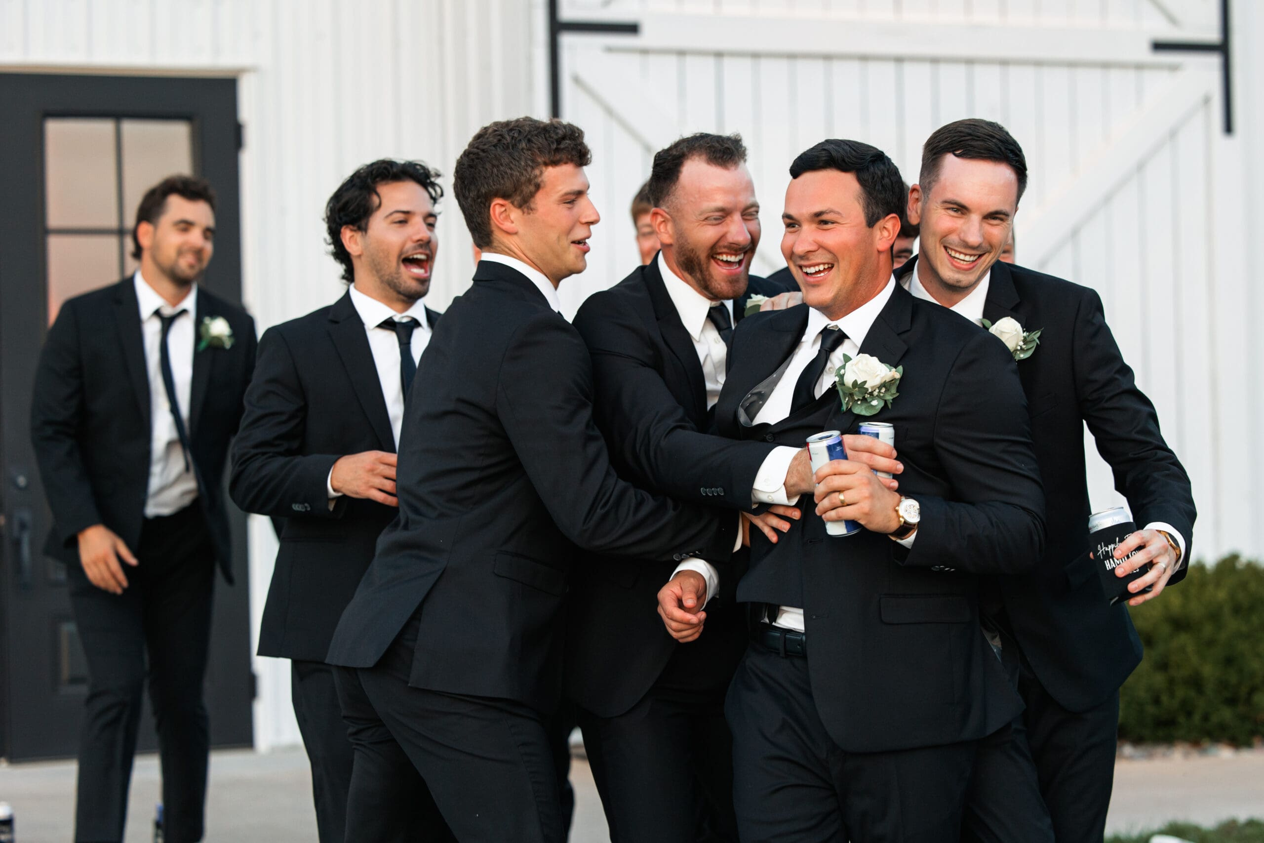 Groomsmen hugging groom Barn at Grace Hill wedding.