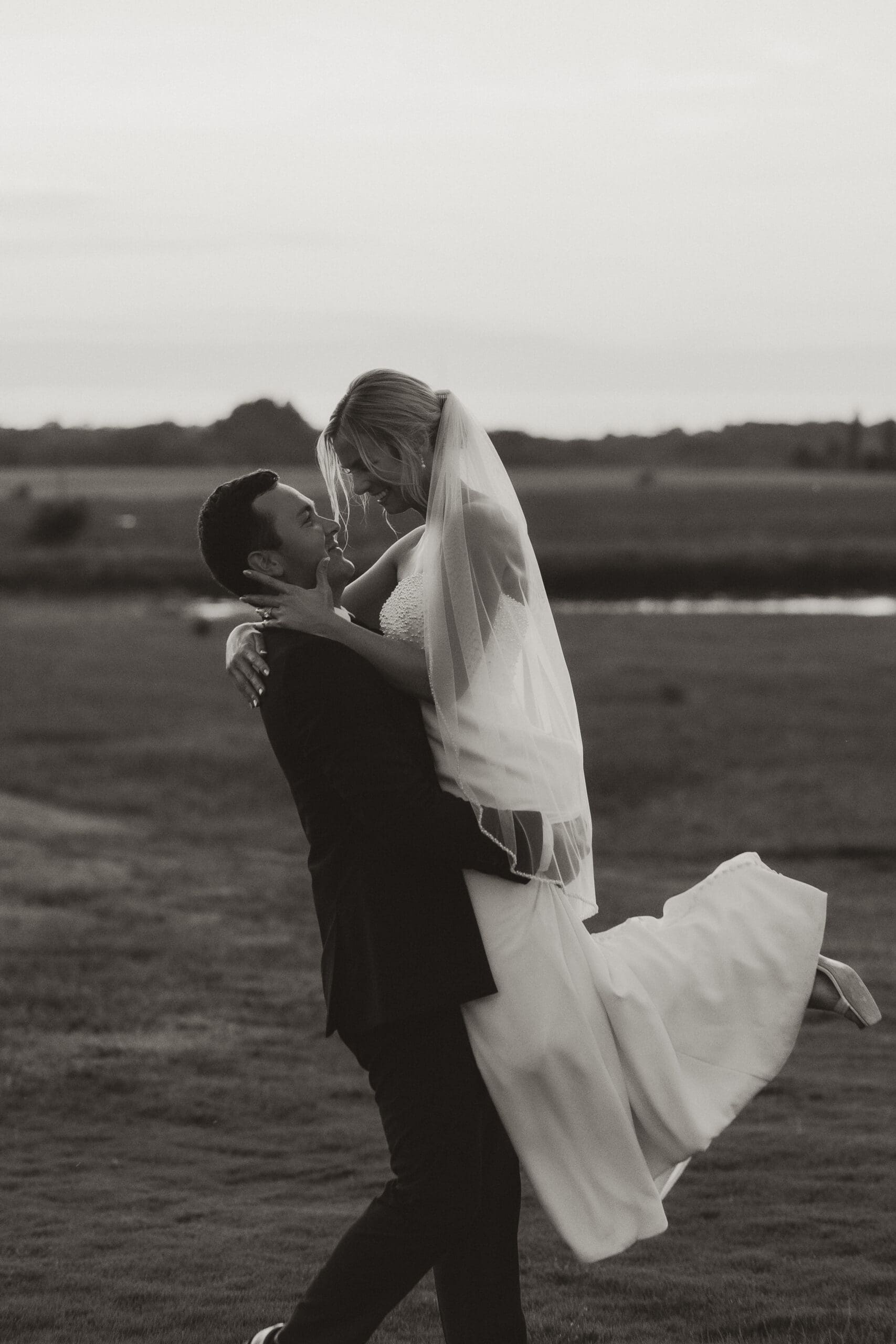 Groom swinging bride in the air golden hour Barn at Grace Hill.
