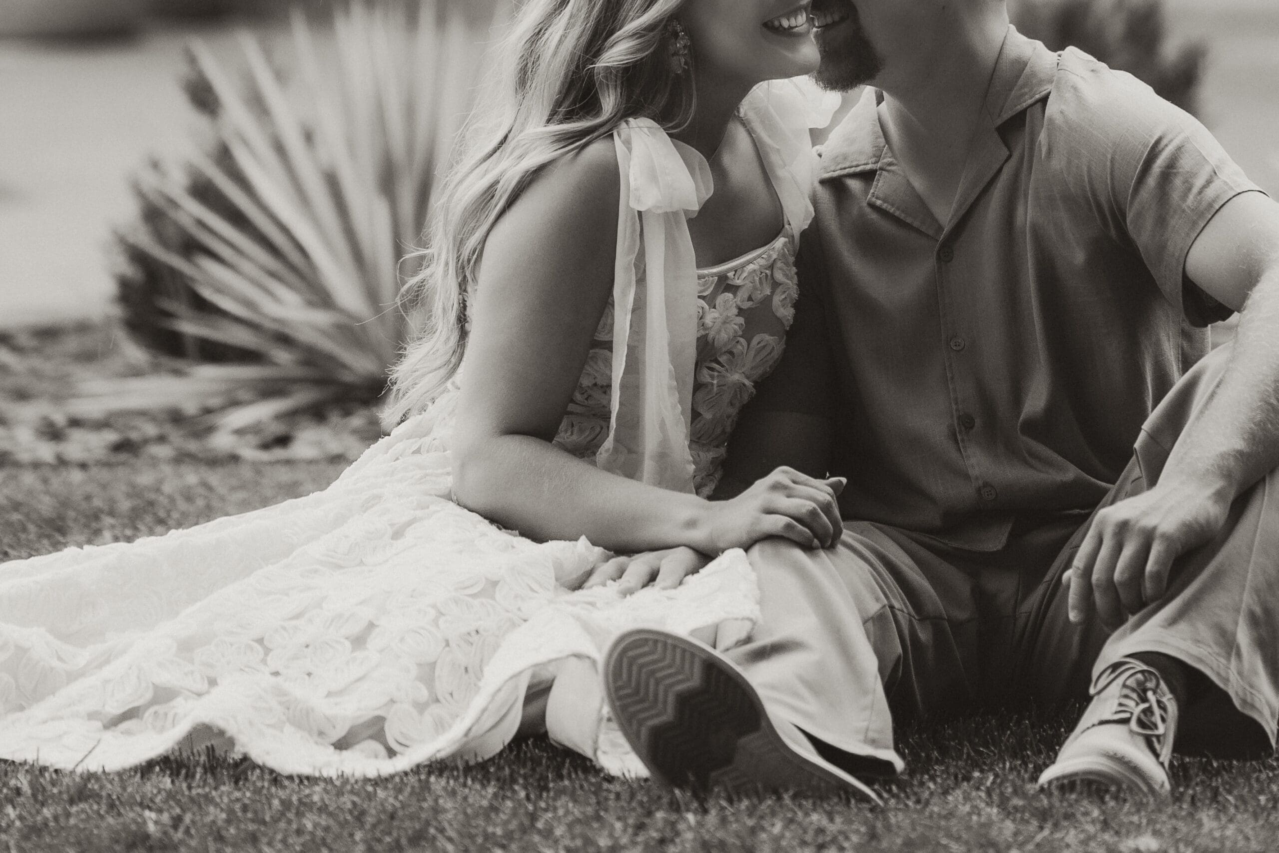 Detail of bride and groom sitting closely on the lawn. Wichita Engagement Photographer