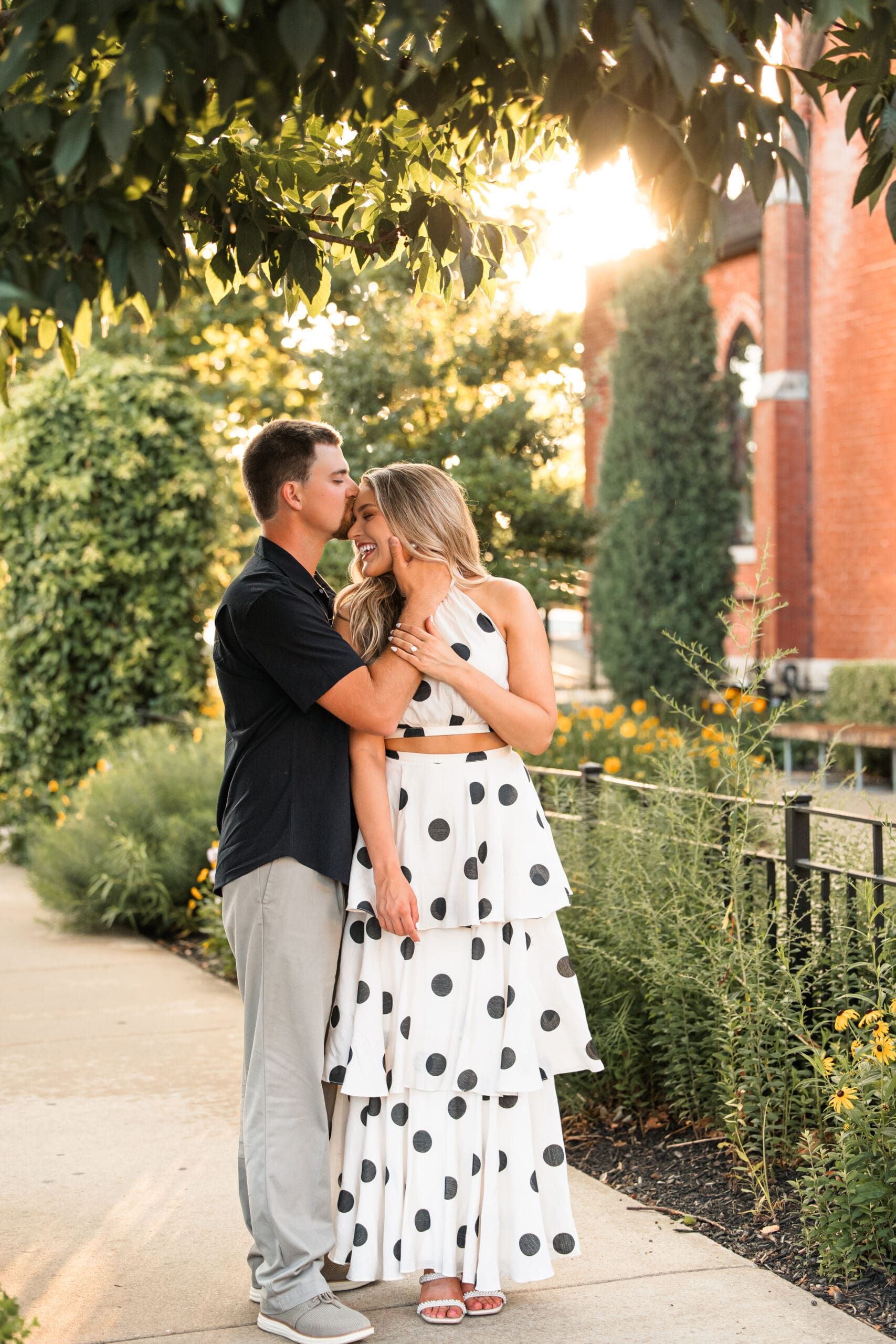Groom kisses bride’s temple as she softly smiles. Wichita Wedding Photographer