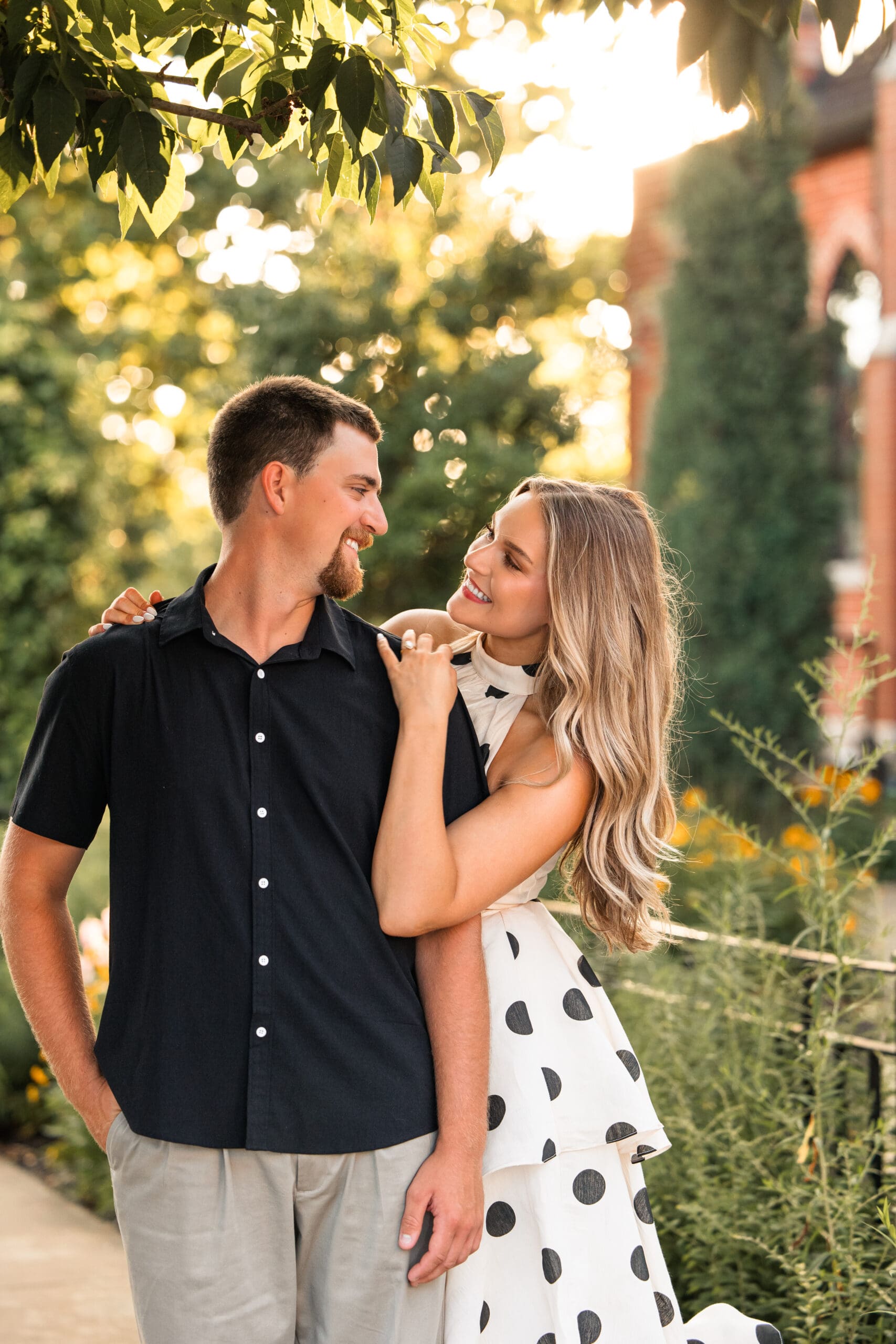 Bride looks lovingly at groom as she leans over his shoulder. Wichita Wedding Photographer