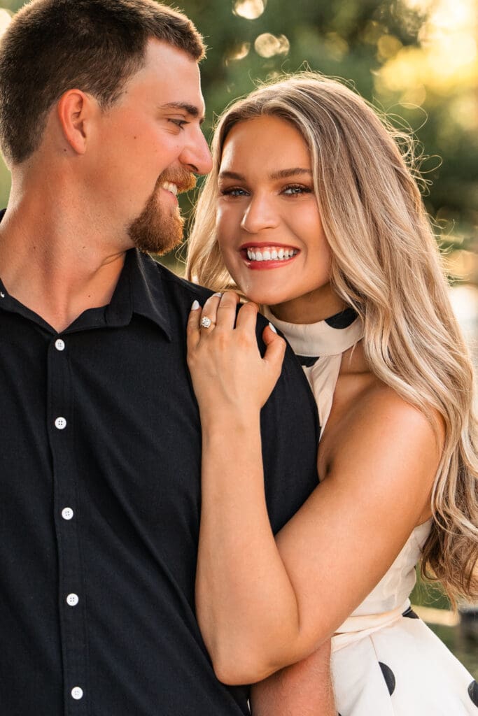 Bride looks confidently at camera as groom smiles at her. Wichita Wedding Photographer