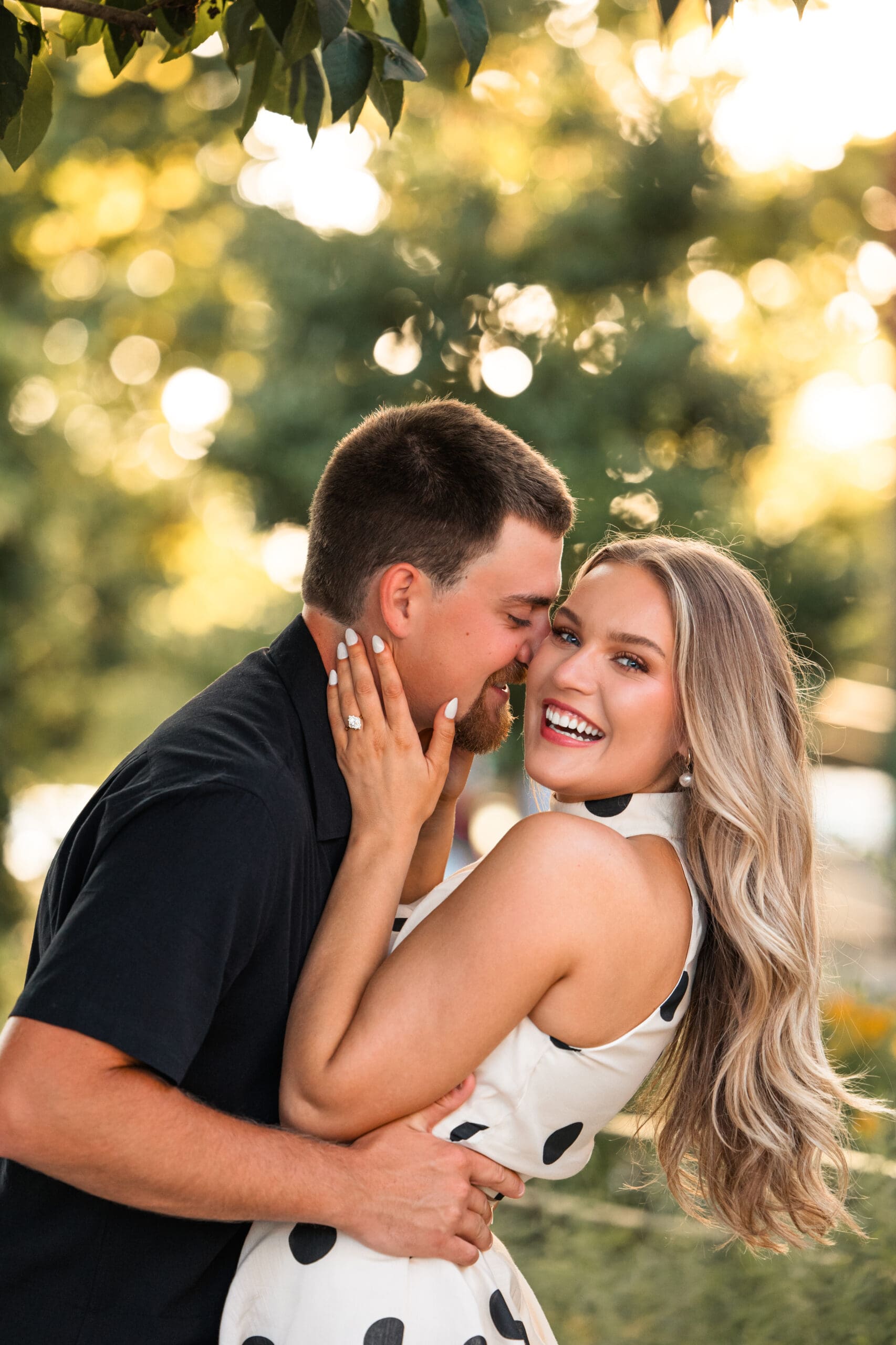 Bride smiles at camera while groom admires her 