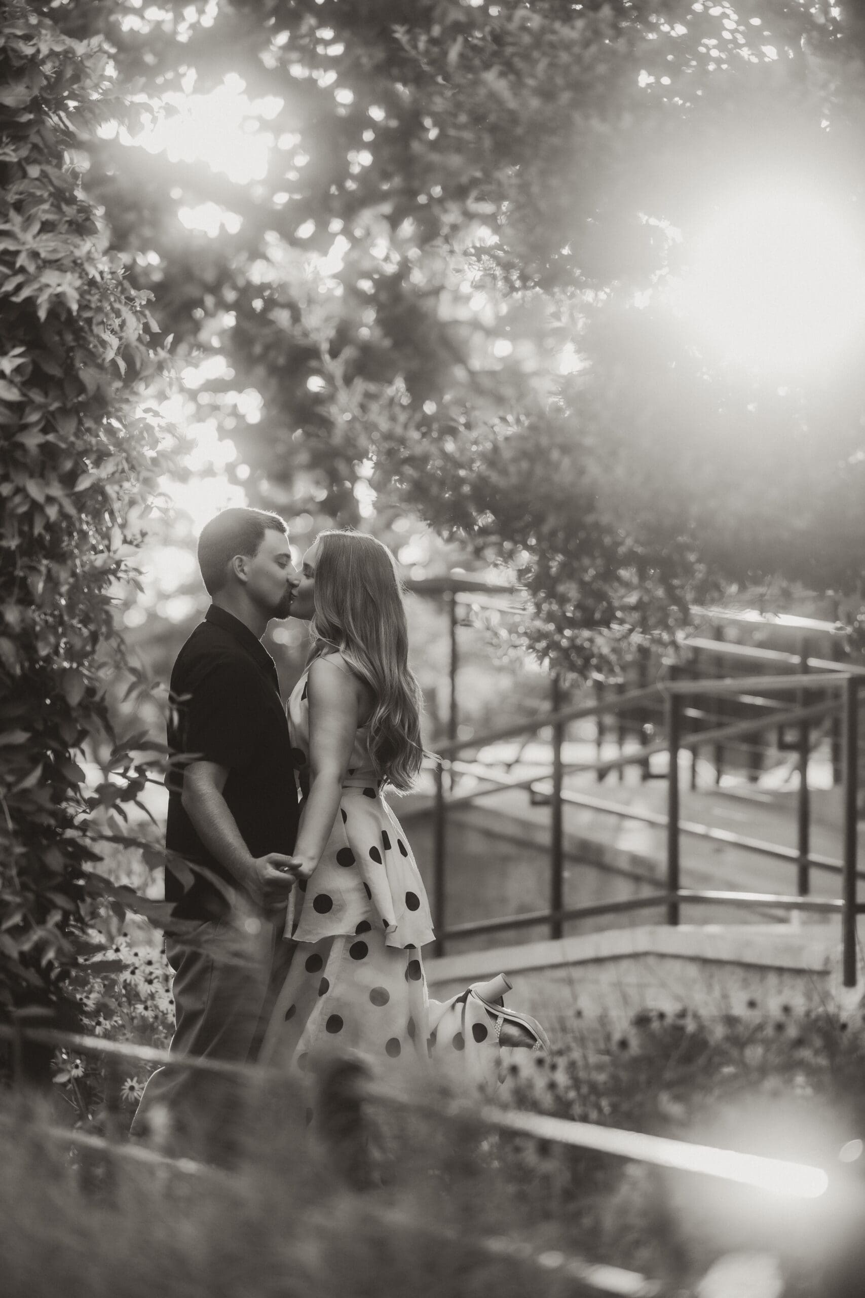 Bride and groom share a kiss framed by moody tones. 