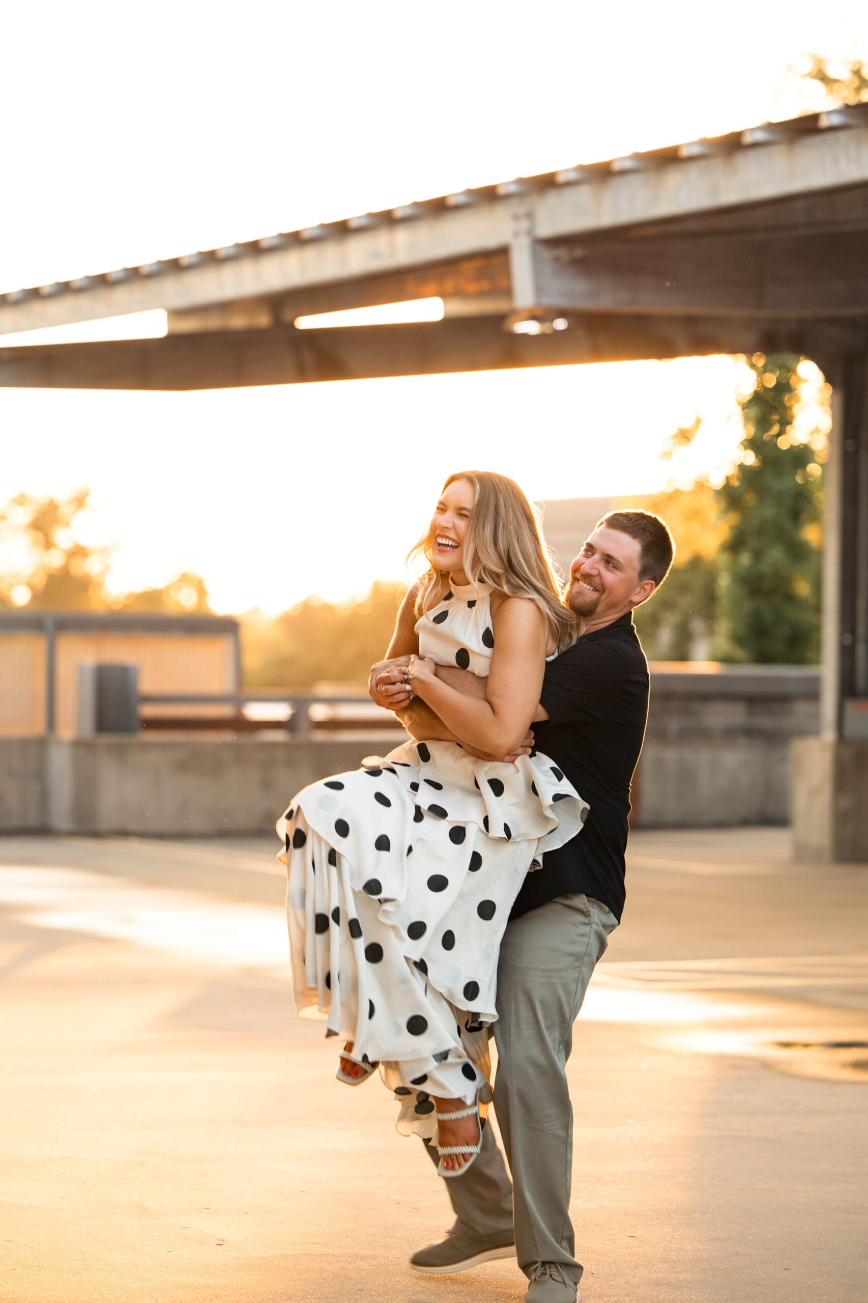 Groom lifts bride from behind with joyful energy.