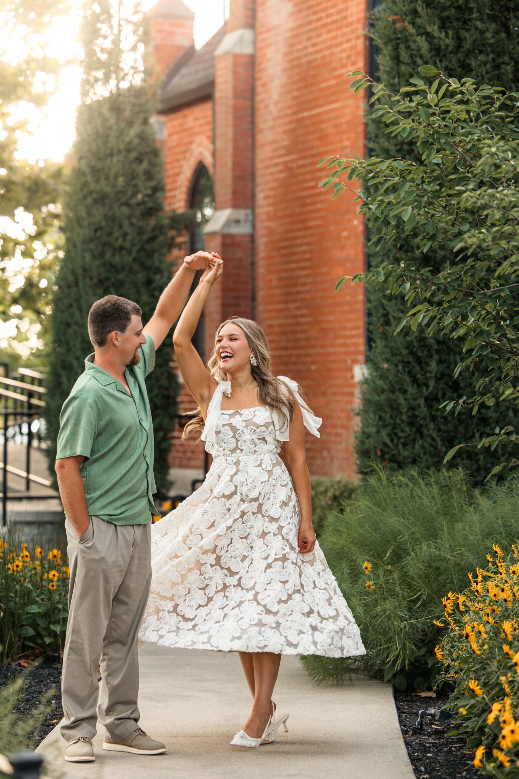 Groom twirls bride as she laughs joyfully. Wichita Engagement Photographer