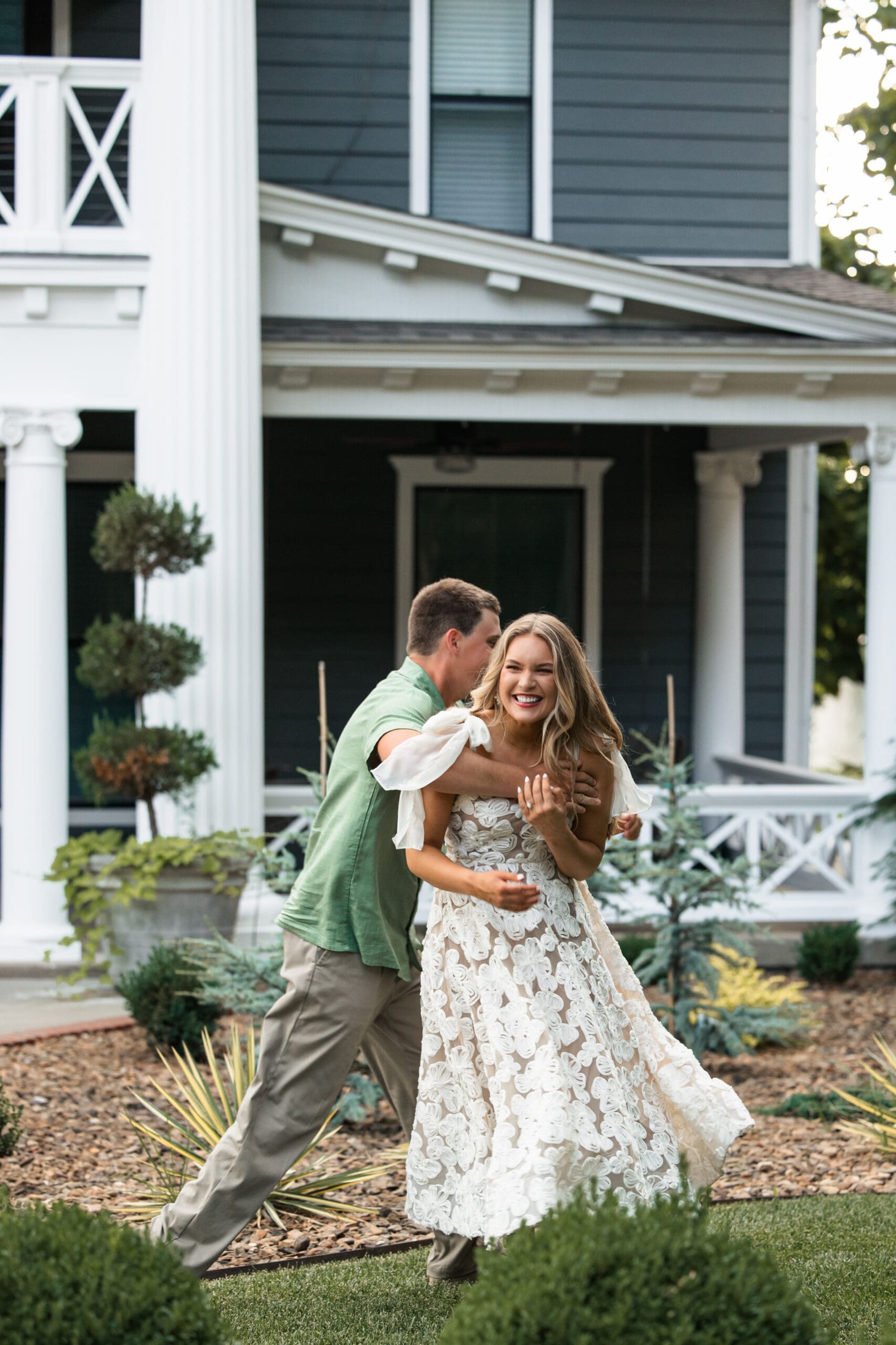 Groom catches bride mid-chase in a playful backyard scene. Wichita Engagement Photographer