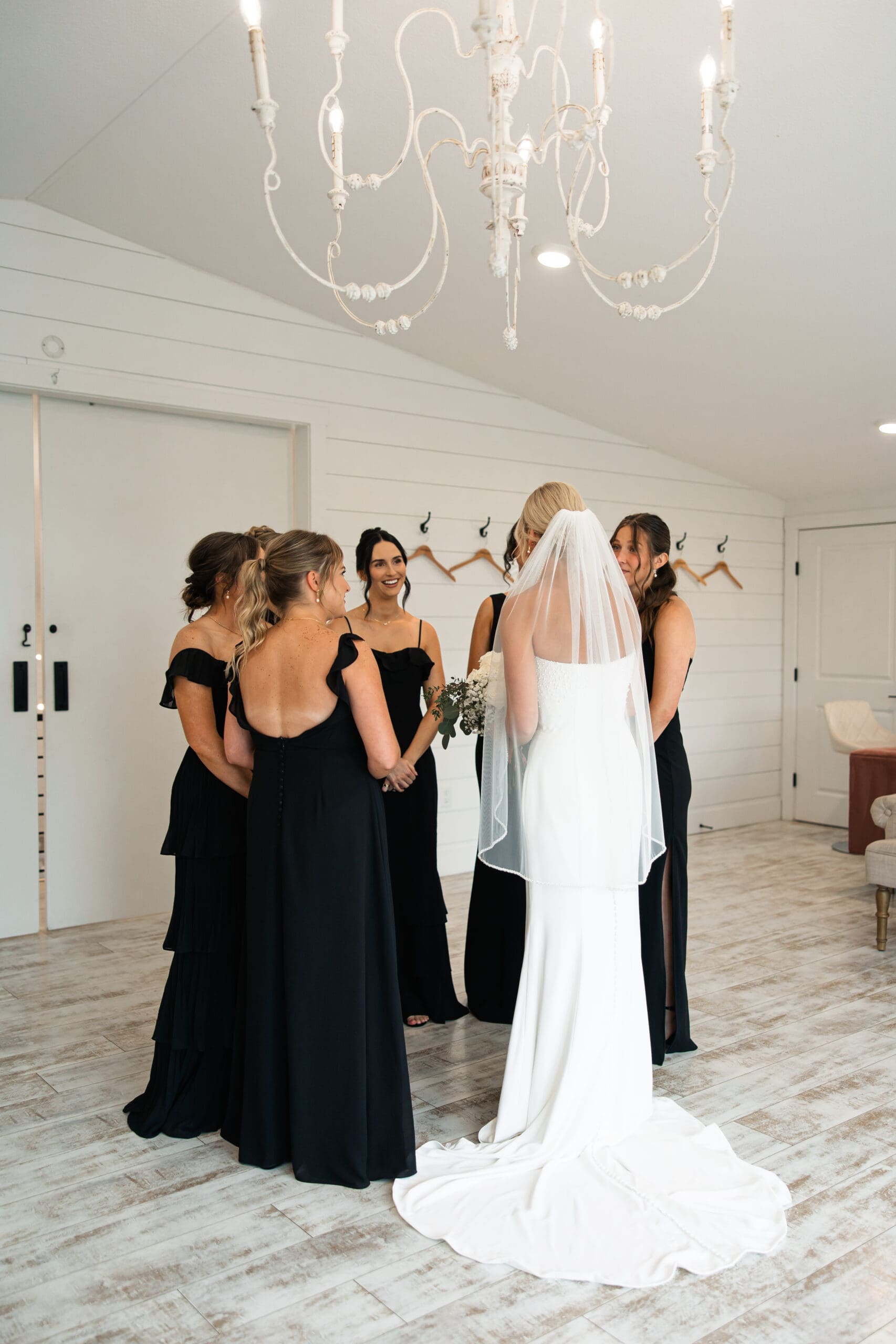 Bride laughing with bridesmaids gathered in a circle Barn at Grace Hill.
