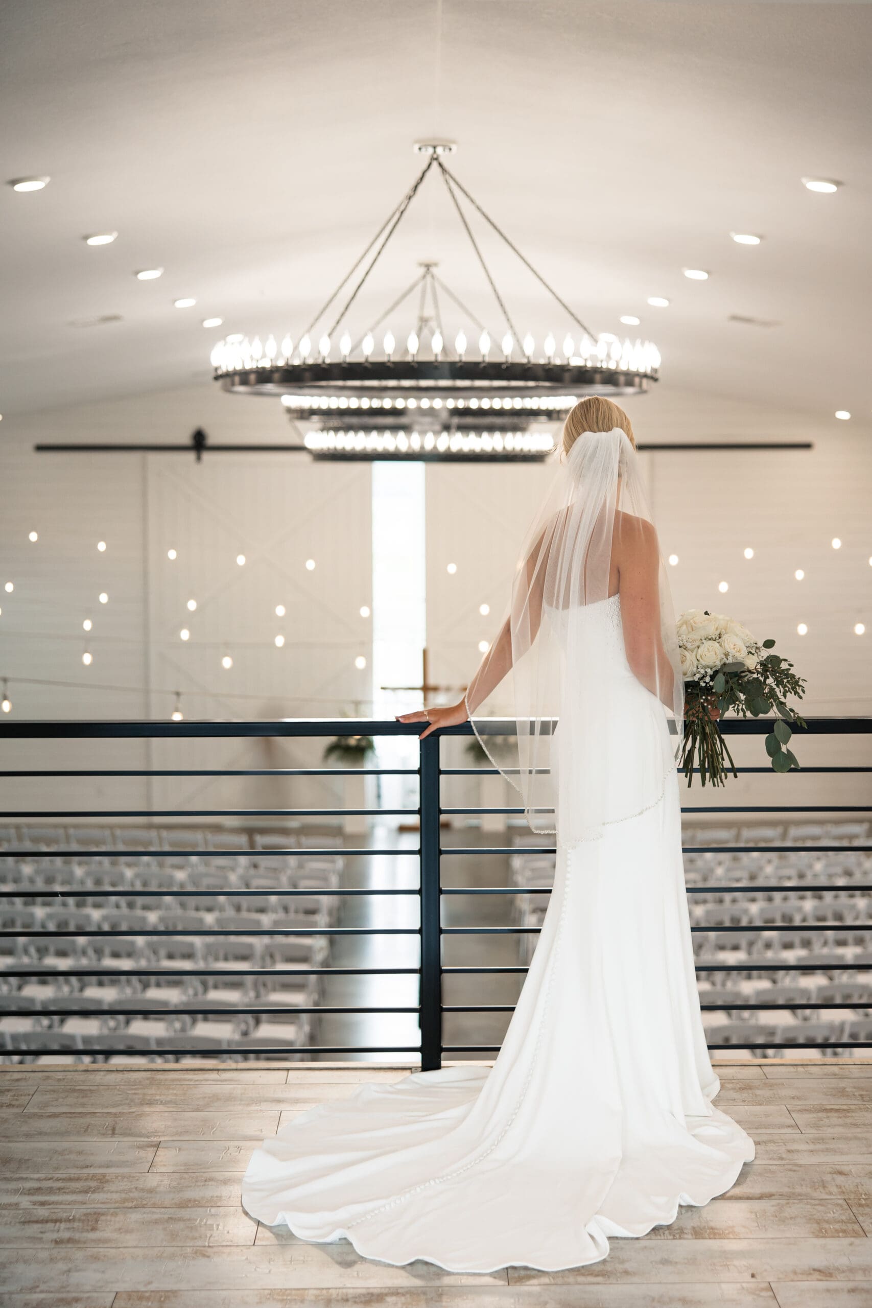 Bride looking over ceremony space from balcony 