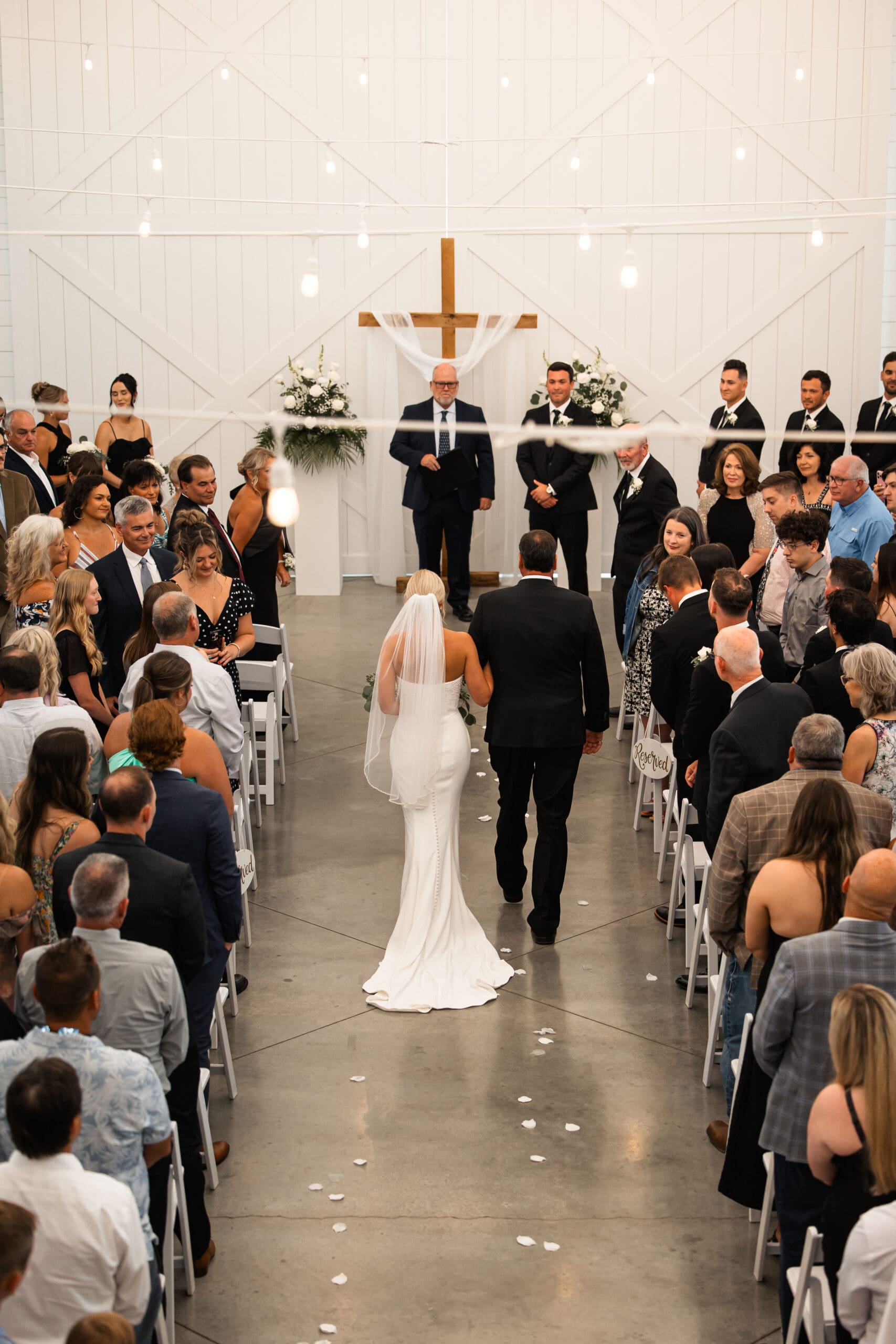 Bride and dad walking down aisle toward groom Barn at Grace Hill.