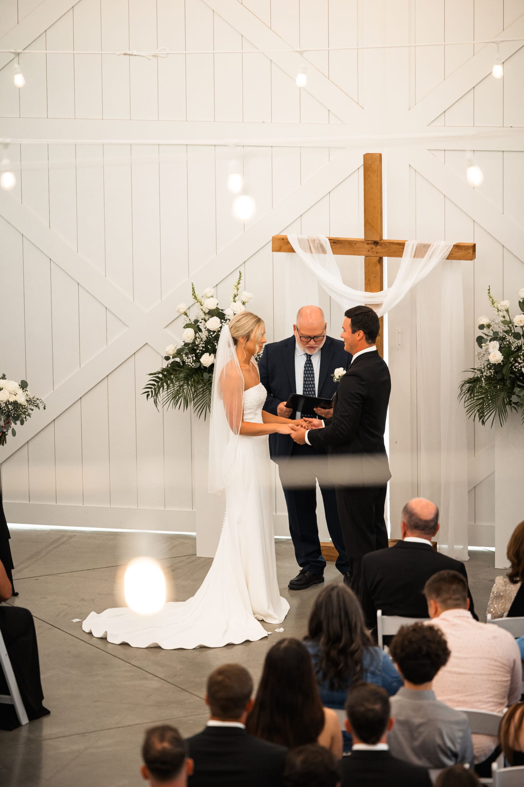 Bride and groom holding hands during ceremony Barn at Grace Hill.