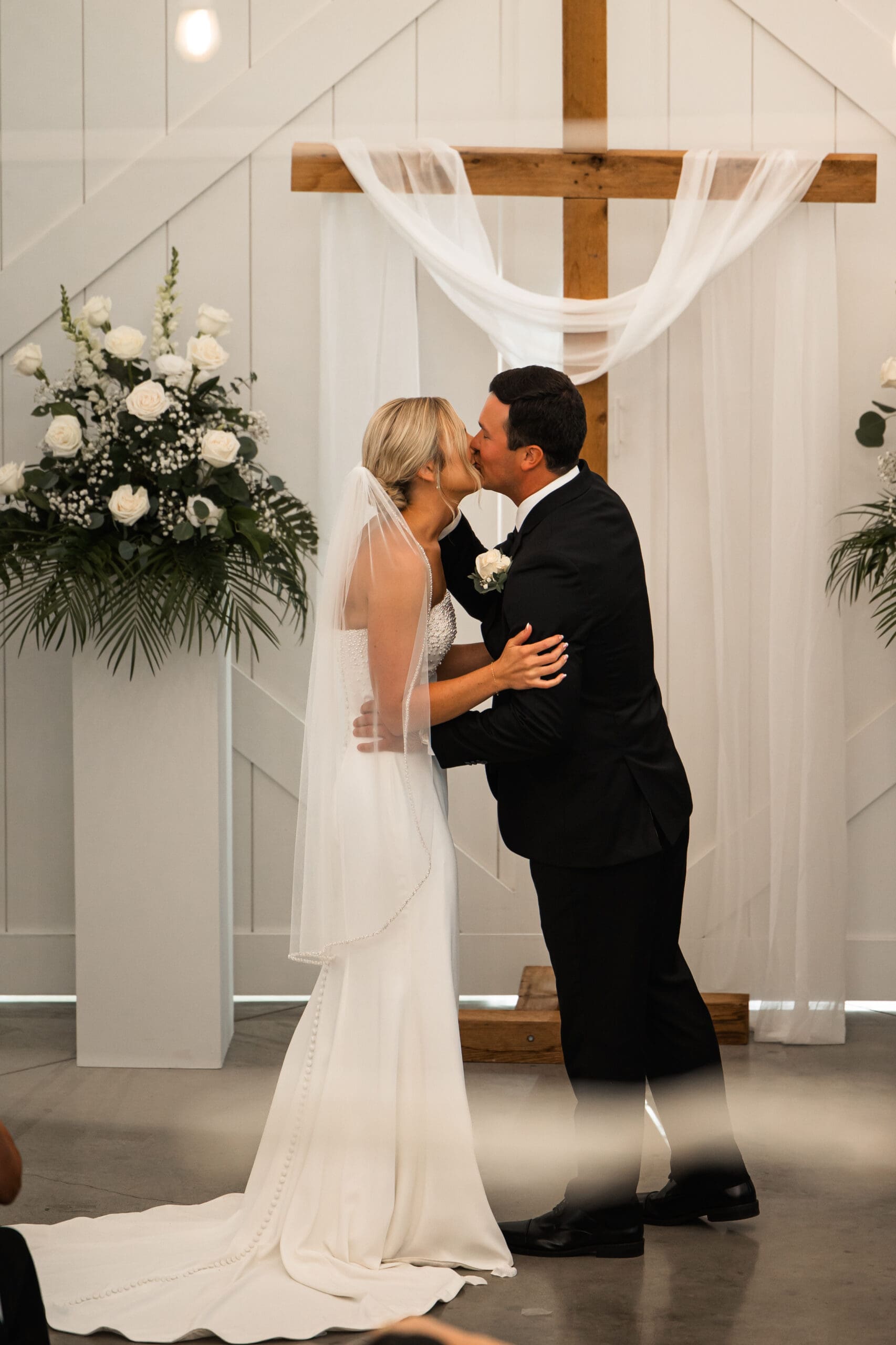 Bride and groom first kiss Barn at Grace Hill ceremony.