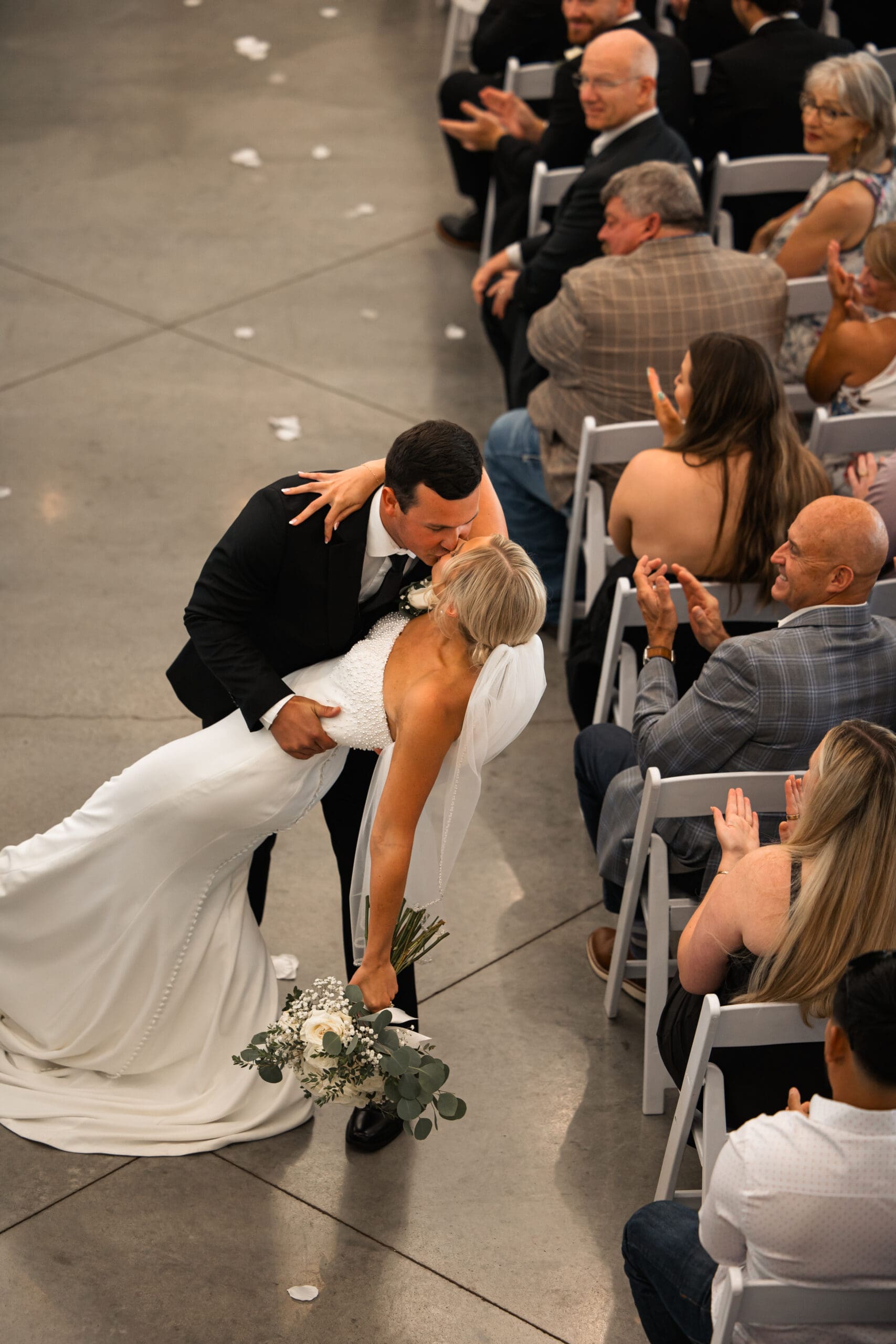 Bride and groom dip kiss down aisle Barn at Grace Hill wedding.