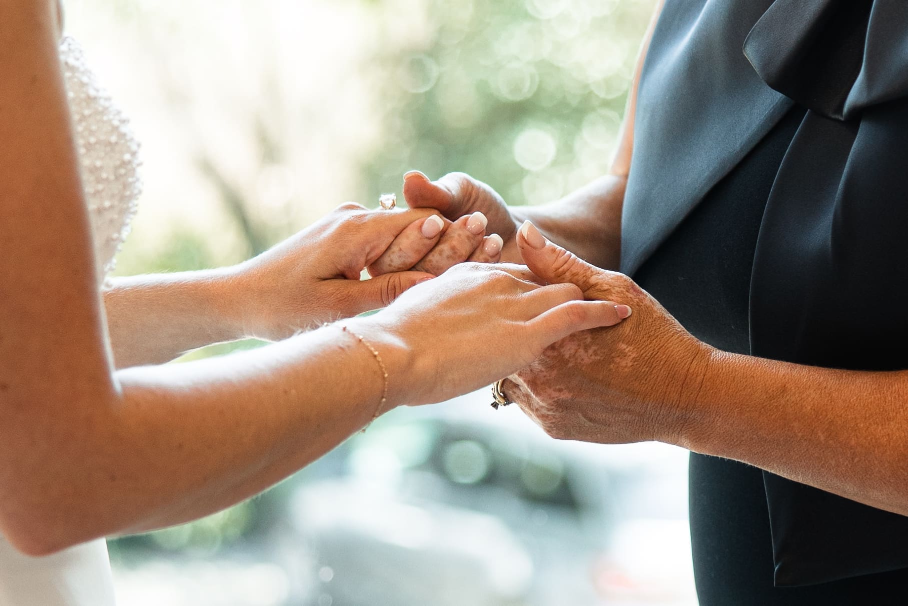 Bride and mom holding hands before ceremony 