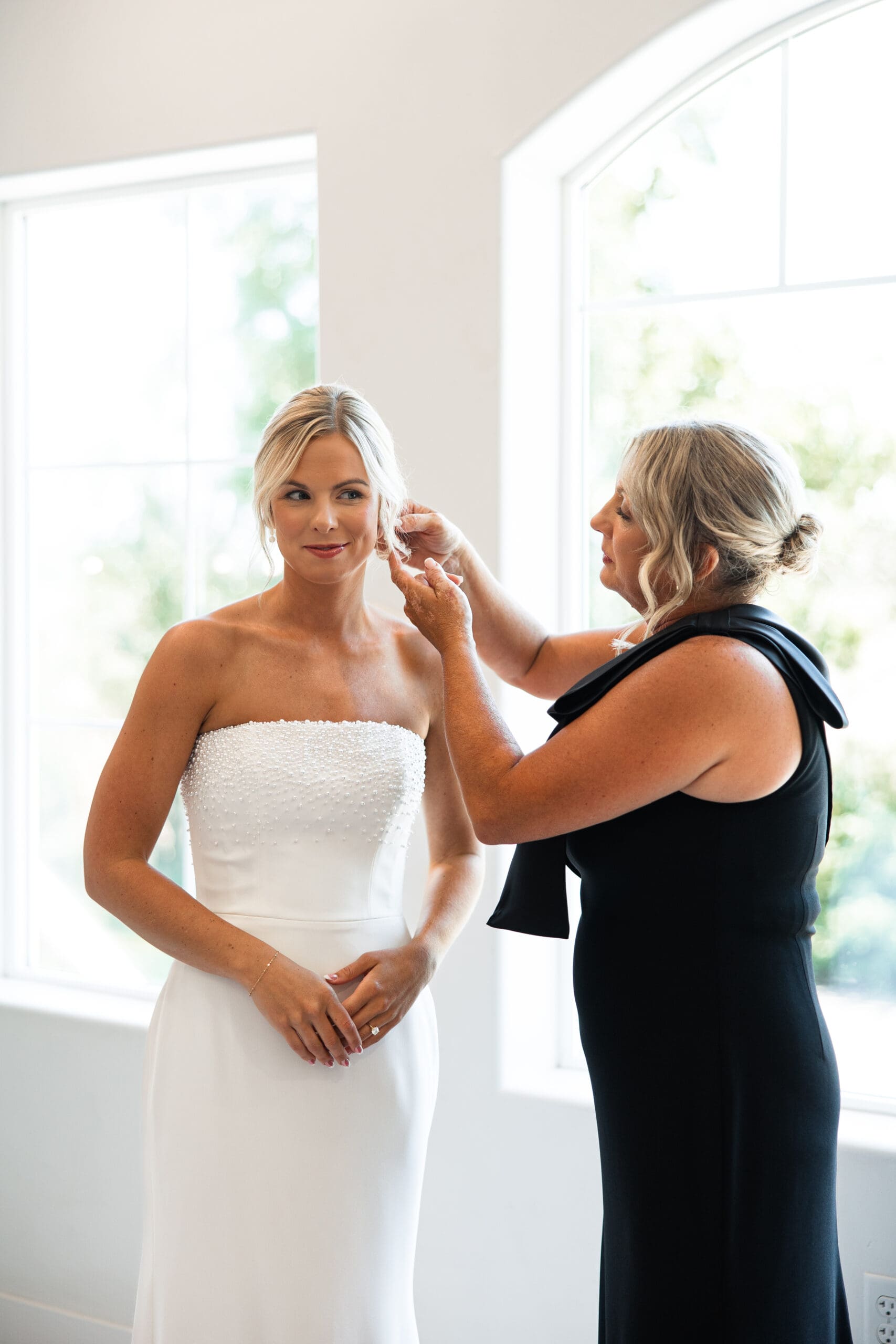 Mom helping bride put on jewelry 
