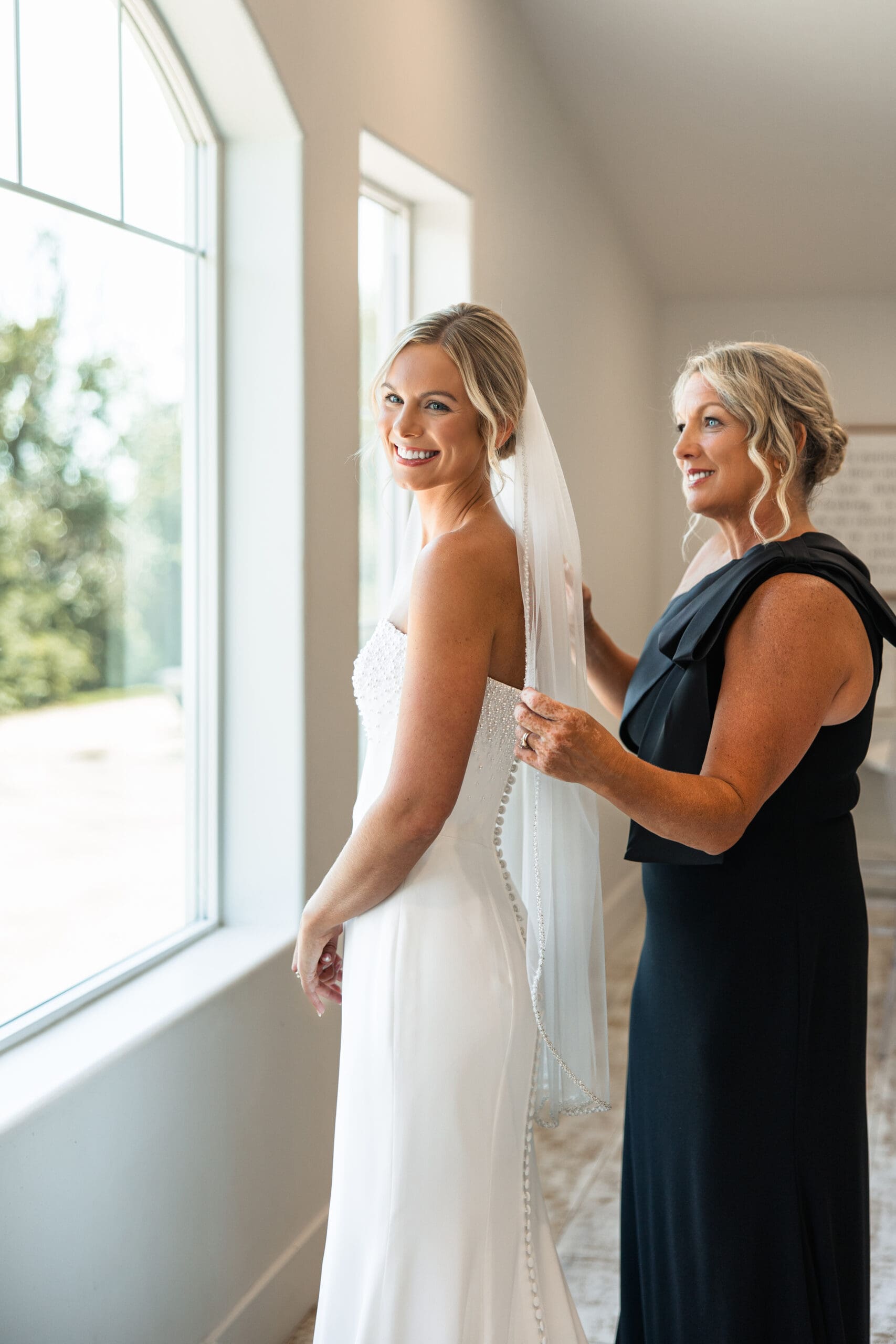 Mom adjusting bride’s veil before Barn at Grace Hill wedding.