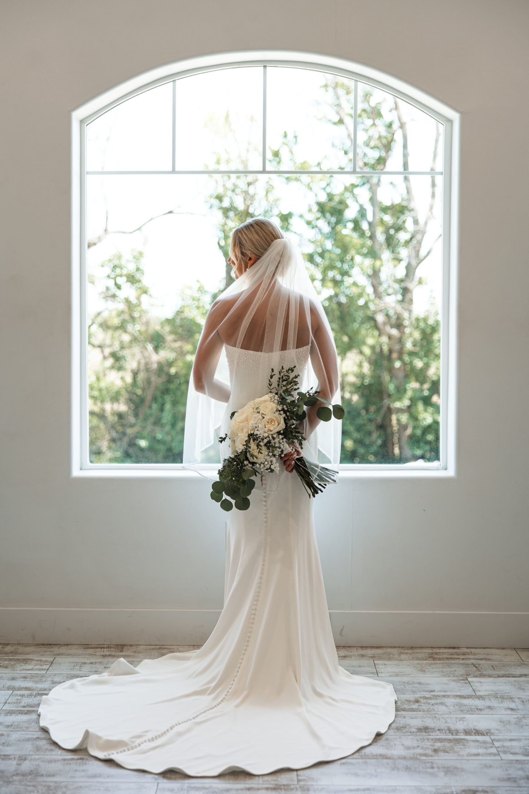Bride holding bouquet behind back 
