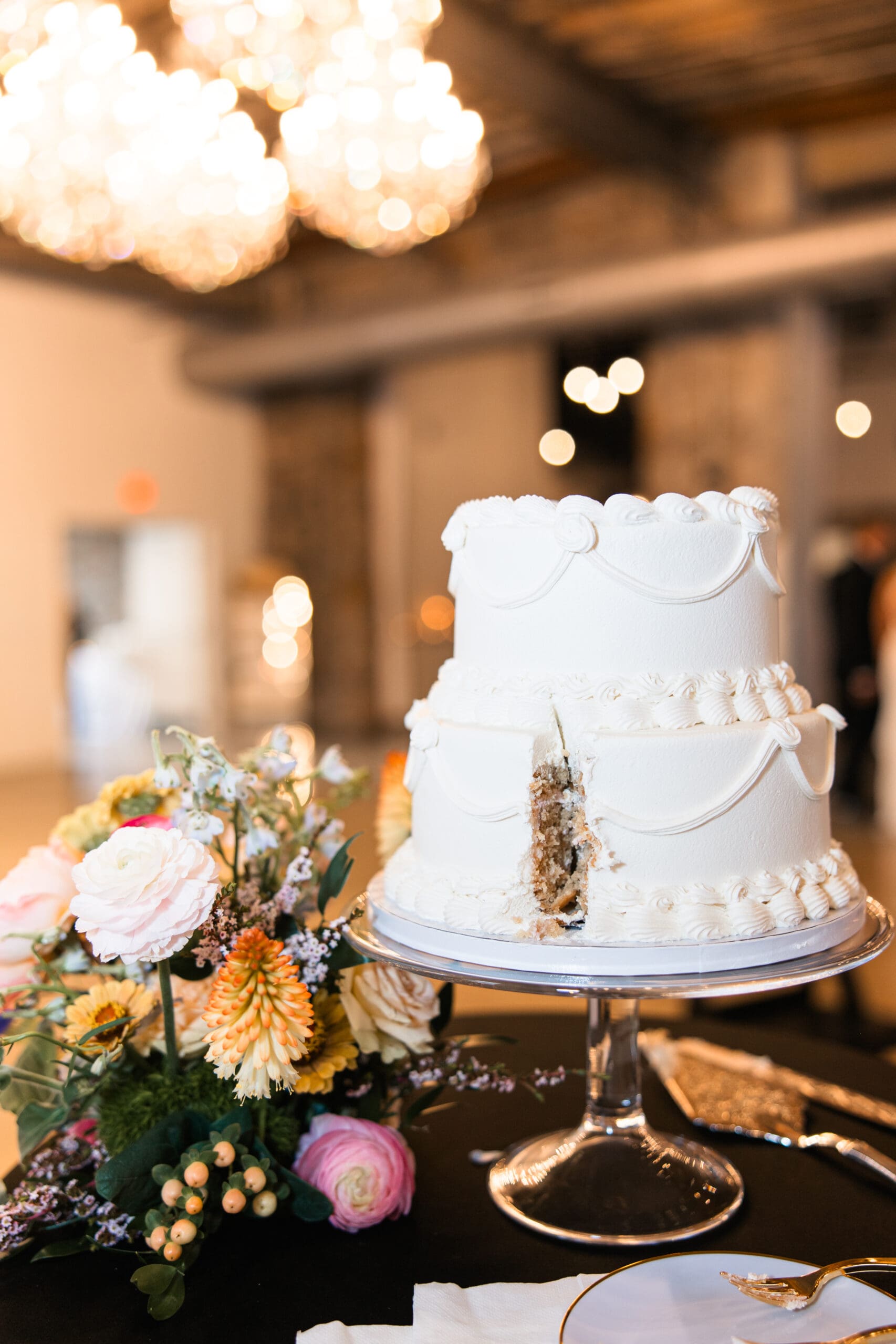 Classic white tiered wedding cake with fresh floral details at Stone Manor on 79th in Overland Park, Kansas.