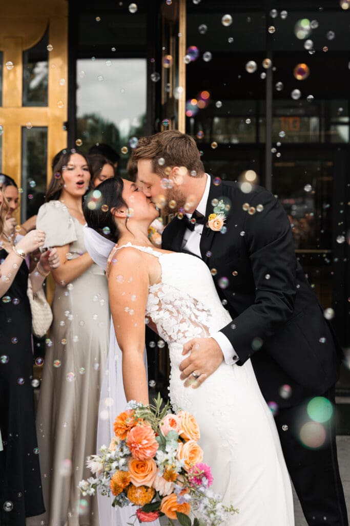 Romantic wedding bubble exit kiss outside Holy Spirit Catholic Parish in Overland Park, Kansas