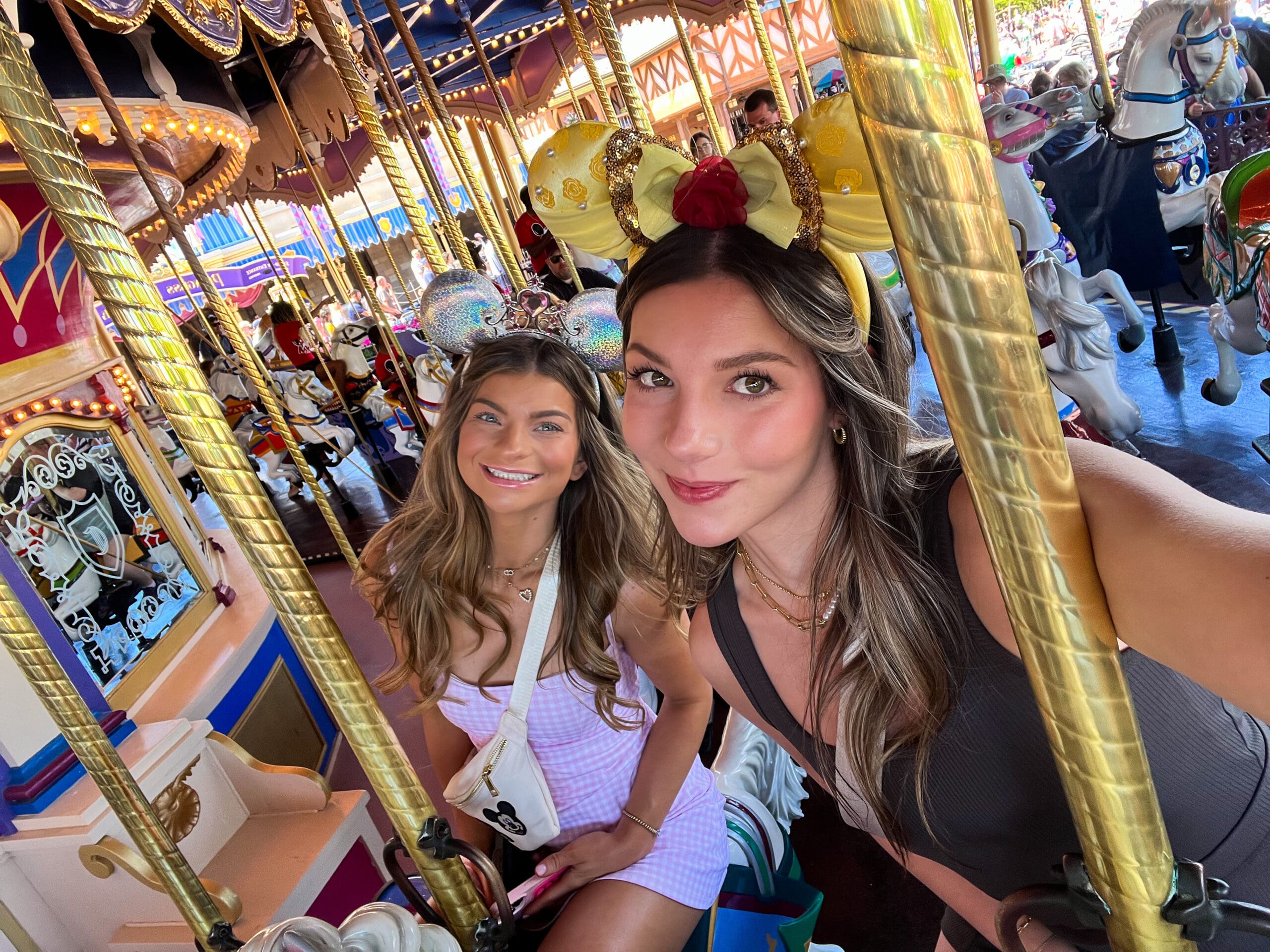 Two friends riding the Prince Charming Regal Carrousel at Magic Kingdom Disney World – spinning fun and golden horses under vibrant lights in Orlando