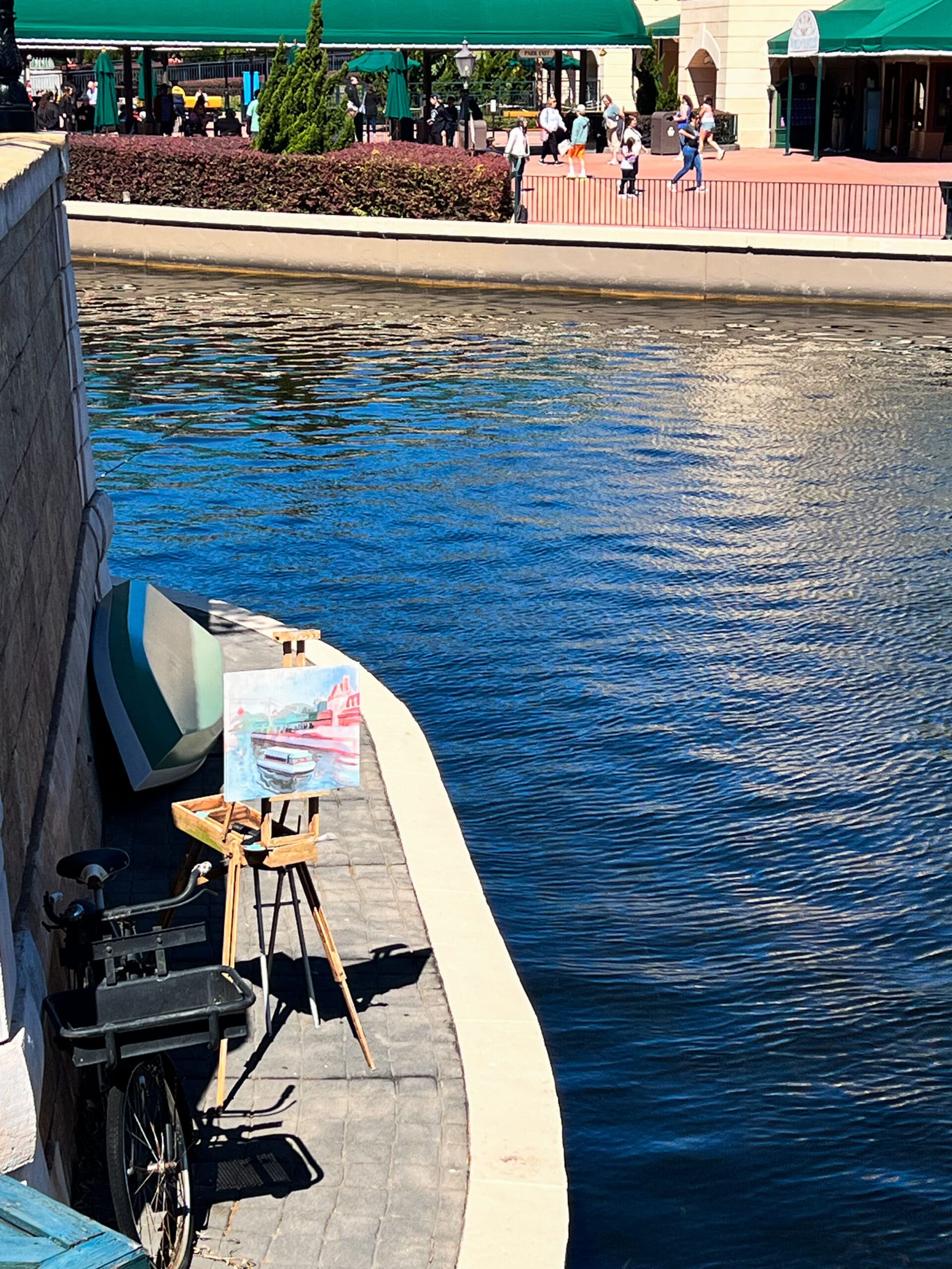 Street artist painting colorful waterway scene with easel at Disney Springs Orlando – creative evening vibes after boutique collection styled session
