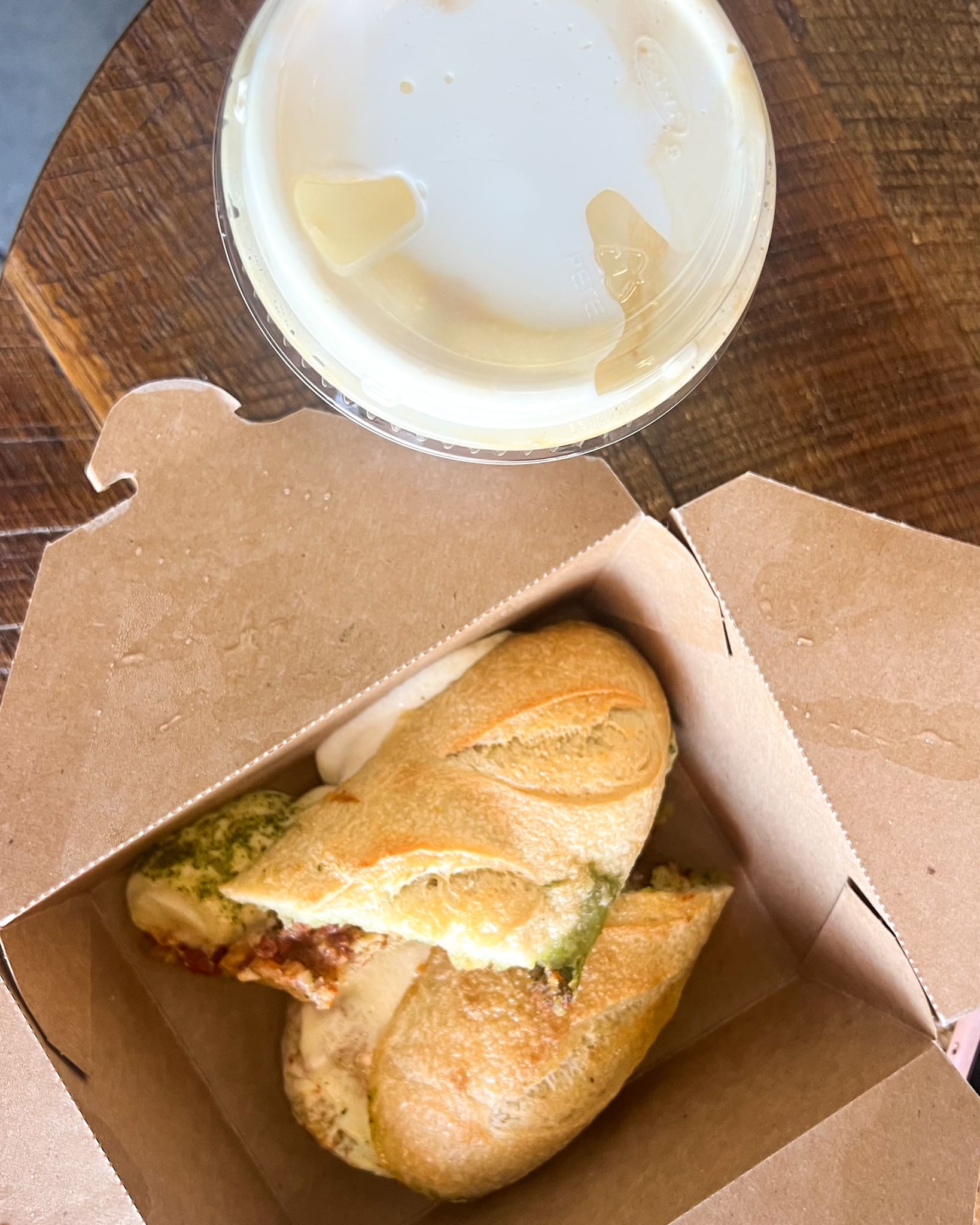 Mozzarella pesto tomato panini and iced vanilla latte on table at Foxtail Coffee Co. Orlando – perfect morning fuel before Leu Gardens styled shoot with Ave & Liv boutique