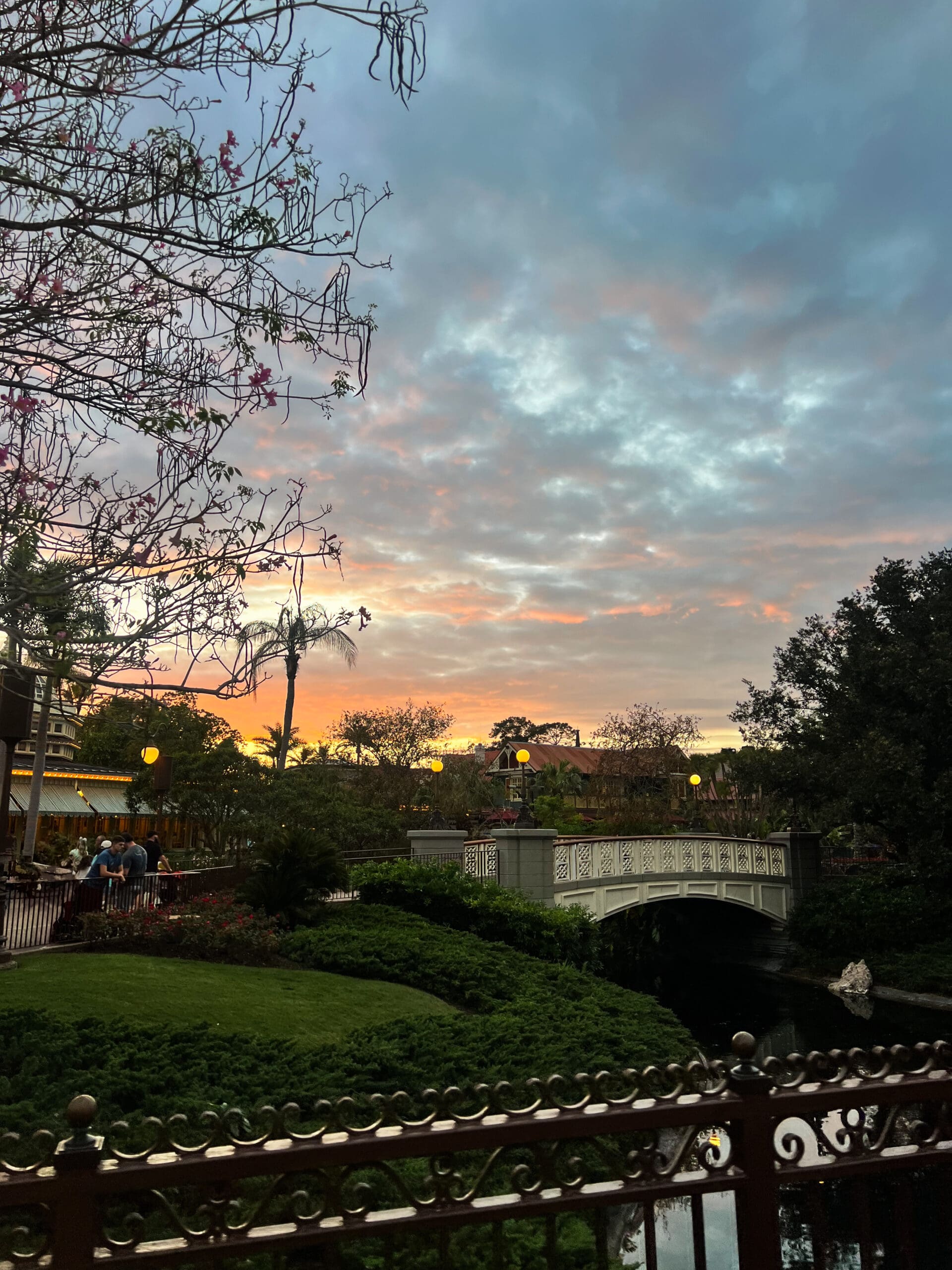 Romantic bridge over water with pink and orange sunset sky at Disney World Orlando – golden hour magic after Ave & Liv boutique shoot