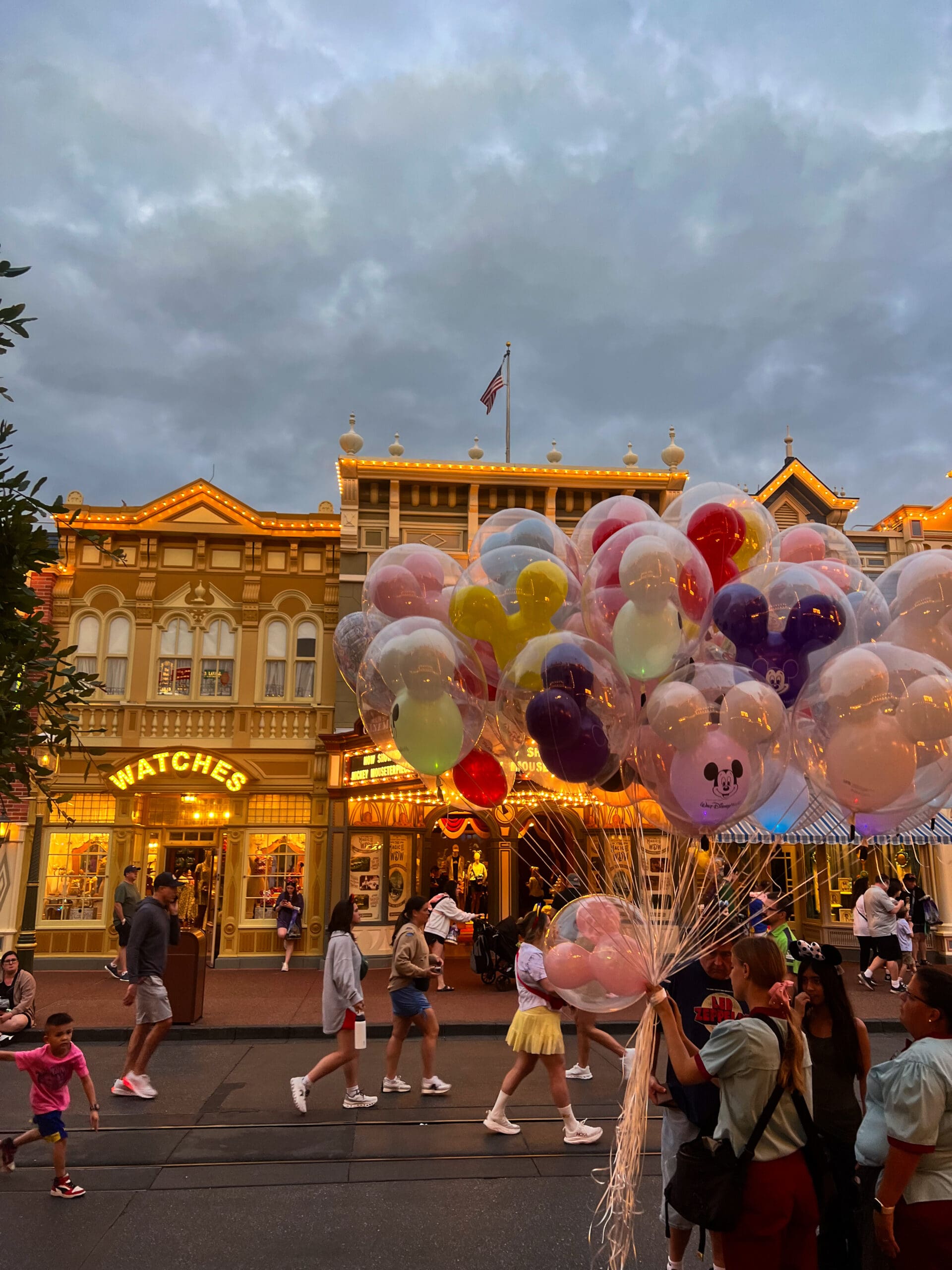 Cluster of colorful Mickey balloons floating in front of Cinderella Castle at Magic Kingdom Disney World during sunset – pure Disney magic in Orlando