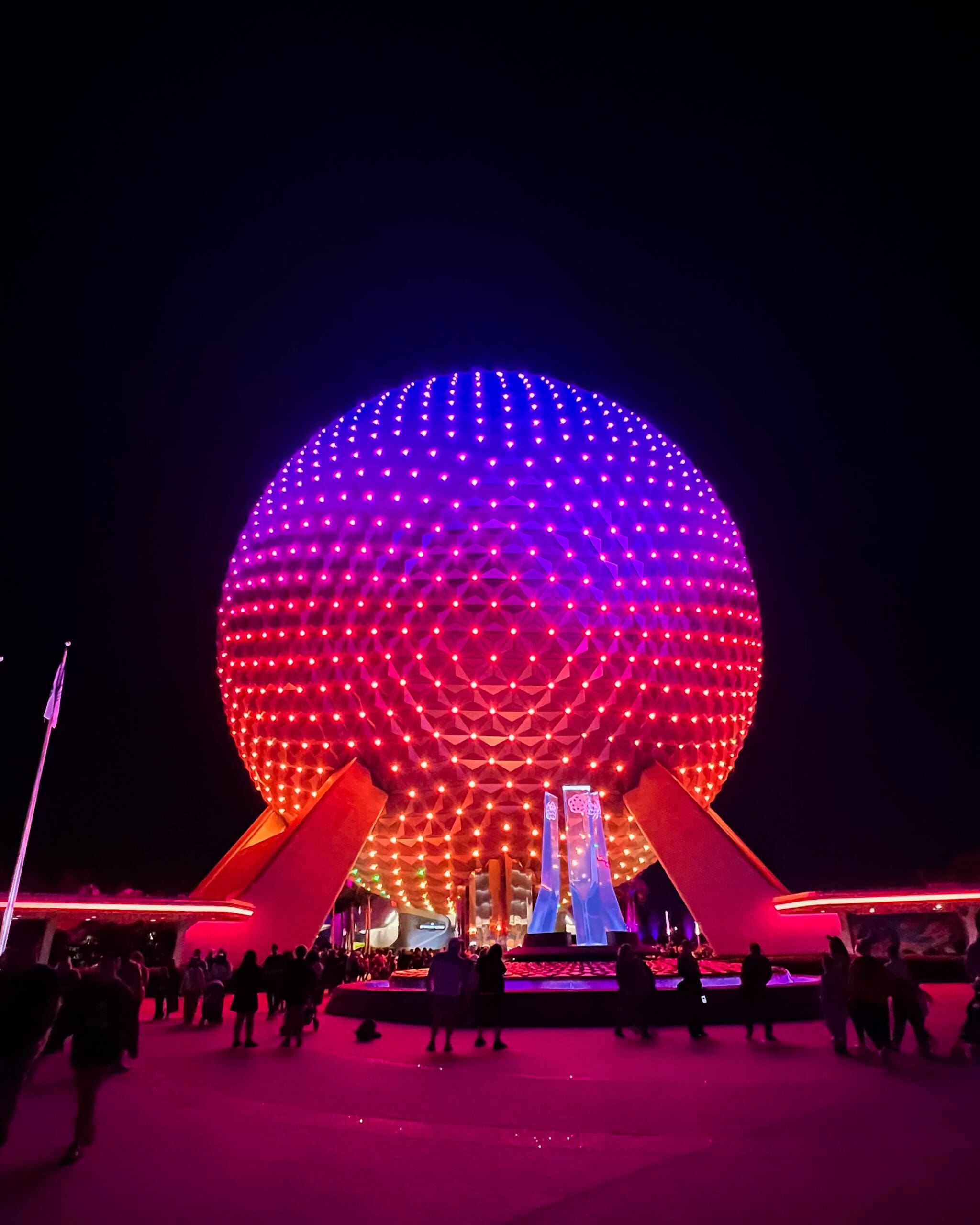 Spaceship Earth glowing with vibrant purple and blue lights at night in Epcot Disney World – spectacular nighttime illuminations captured during Orlando Disney adventure
