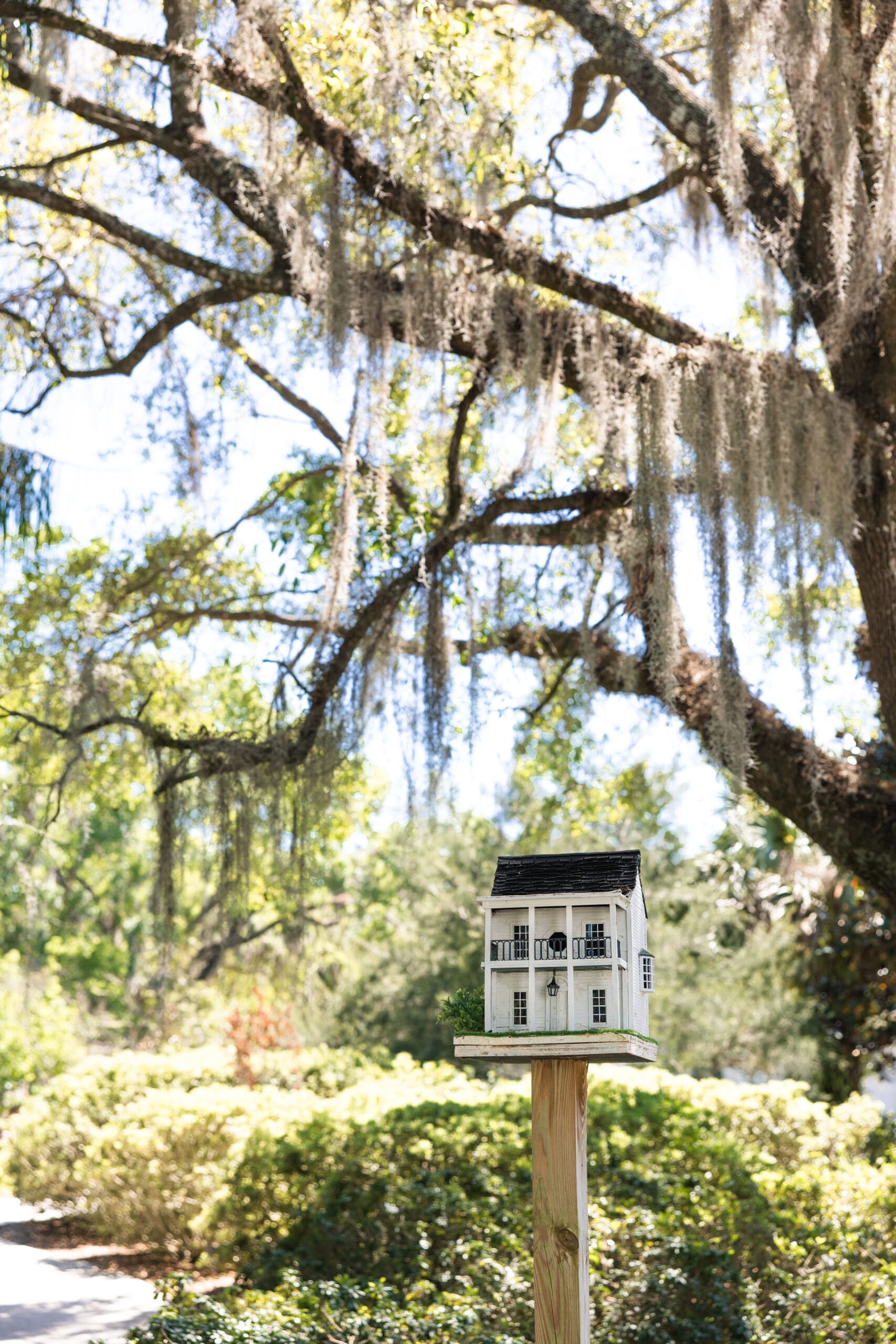 Charming white birdhouse on wooden post surrounded by Spanish moss oaks at Harry P. Leu Gardens Orlando – whimsical detail from Ave & Liv boutique styled shoot