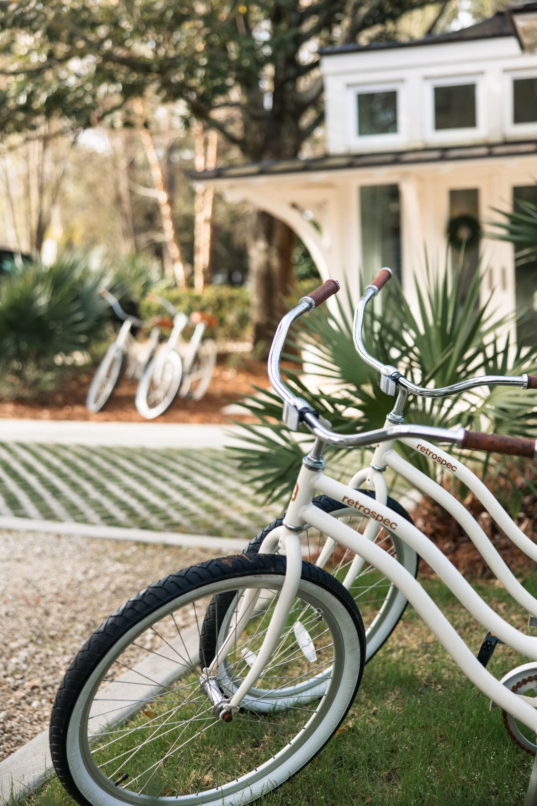 White Retrospec cruiser bicycle with brown leather grips in the foreground during a Fairhope Alabama photoshoot at Lucia Bleu Fairhope Cottages